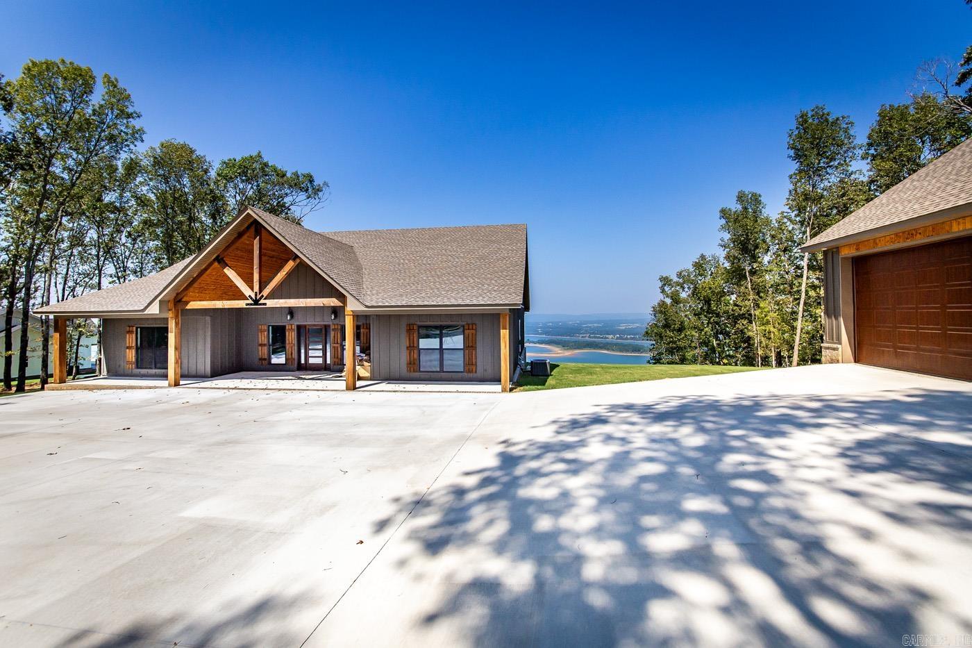 NEW HOME (built in 2023) with the most beautiful views of Greers Ferry Lake that you'll ever see! Sitting on a large 3-acre wooded lot in a new 6-lot subdivision overlooking GFL and the Narrows to the north. Open floorplan with vaulted ceilings and exposed beams, LVP flooring that matches the rustic setting, large covered pack porch that flows perfectly from the interior living space! Lovely open kitchen with lots of cabinetry, large island with breakfast bar, and stainless appliances! Primary bedroom has wonderful views of GFL, spacious walk-in closet, walk-in shower and separate tub plus his and hers vanities. 3-car garage is HUGE...perfect for lake toys and/or a multi-functional game room/"fun" space! A lovely home in a very special setting!
