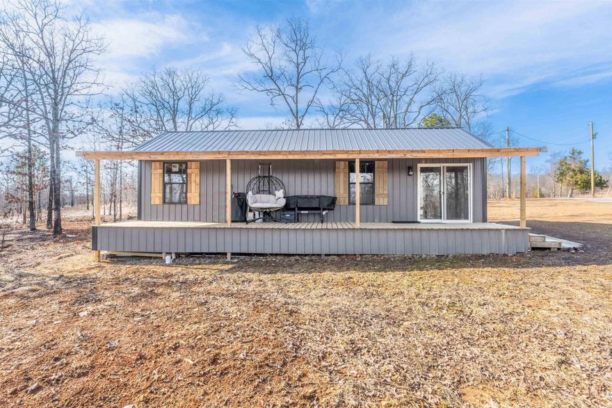 Discover the perfect blend of simplicity and nature with this charming tiny home situated on an expansive 65.4-acre property. This one-bedroom, one-bathroom home features a thoughtfully designed layout with approximately 640 square feet of cozy living space. Constructed with durable metal siding and a metal roof, the home is built to last and withstand the elements. The interior boasts modern amenities, including an electric oven and range, built-in microwave, refrigerator, dishwasher, washer, and dryer. Vinyl flooring and wall-mounted heating add functionality and comfort, while ceiling fans ensure a pleasant living environment.  The sprawling lot offers a picturesque landscape with sloping, wooded terrain, shade trees, and a creek running through the property. Ideal for those seeking privacy and seclusion, this property is perfect for nature enthusiasts, outdoor lovers, or anyone looking to escape the hustle and bustle of city life. With ample room for horses and access via a county road, this unique property provides endless opportunities for relaxation and recreation. Don’t miss the chance to make this tranquil retreat your own. Schedule a showing today! AGENTS SEE REMARKS
