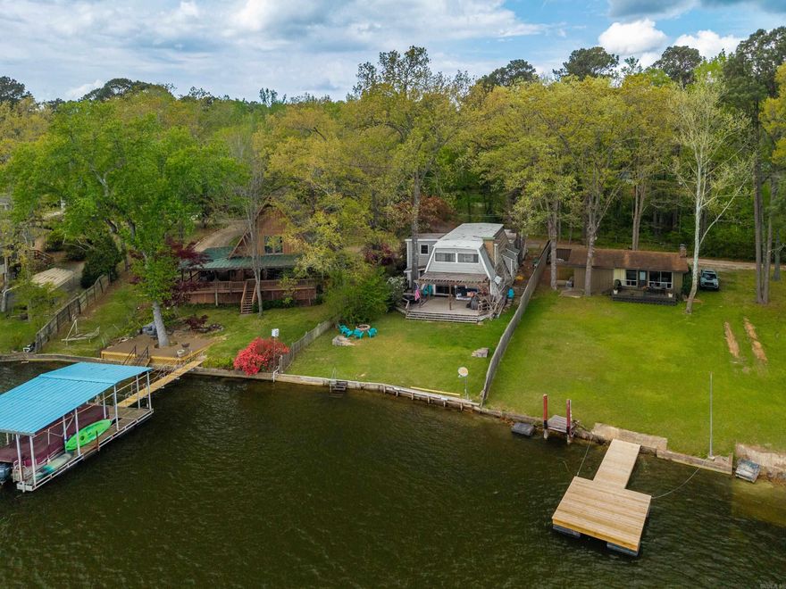 TURNKEY LAKE HAMILTON RETREAT + INCOME PRODUCER Welcome to the ultimate lakefront opportunity—where investment potential meets laid-back luxury living on beautiful Lake Hamilton! Whether you're searching for a high-performing short-term rental or your own private waterfront escape, this property checks every box. Perfectly positioned right on the water and outside city limits (hello STR opportunity!), this fully furnished, turnkey 4-bedroom, 2.5-bath home is ready to start generating income from day one—or to welcome you for unforgettable weekends at the lake. Step inside and fall in love with the warm, inviting character featuring stunning exposed beams, a cozy-yet-modern aesthetic, and thoughtful updates throughout. With over 2,600 sq ft of living space, there’s room for everyone—making it ideal for hosting guests, large families, or maximizing rental occupancy. Imagine mornings with coffee overlooking the water, afternoons spent boating or relaxing lakeside, and evenings winding down with sunset views—this is the lifestyle buyers are searching for. Whether you’re building your portfolio, looking for a second home, or ready to live the lake life full-time, this one delivers!