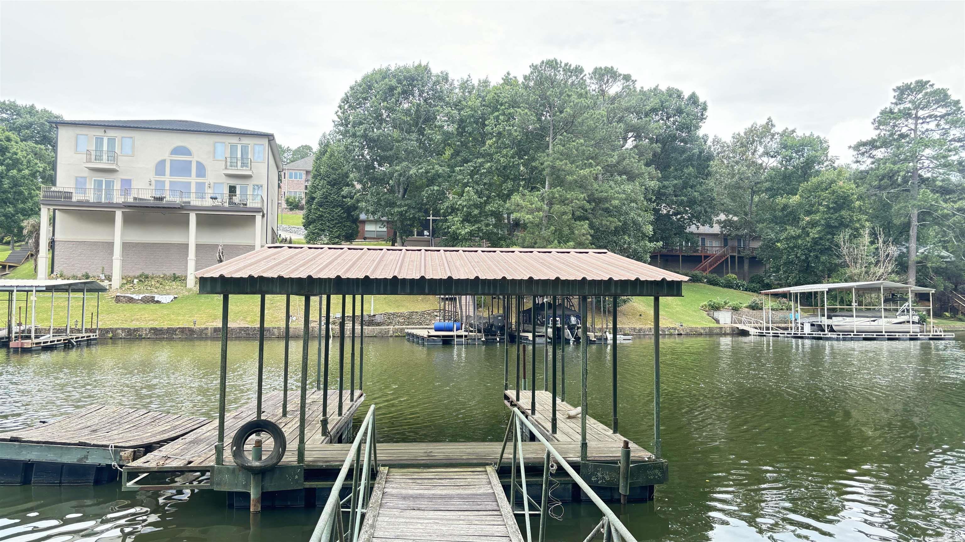 Lakefront! Almost 1 acre lot with approximately 103 feet of lake front! Beautiful setting on major main lake cove! In a neighborhood of half million to million dollar plus homes! Lot has an old homeplace on it that will need to be demoed! Lot has a gentle down hill slope to the lake and is dotted with hardwood trees! Existing 1 slip dock! Agents, please see remarks!