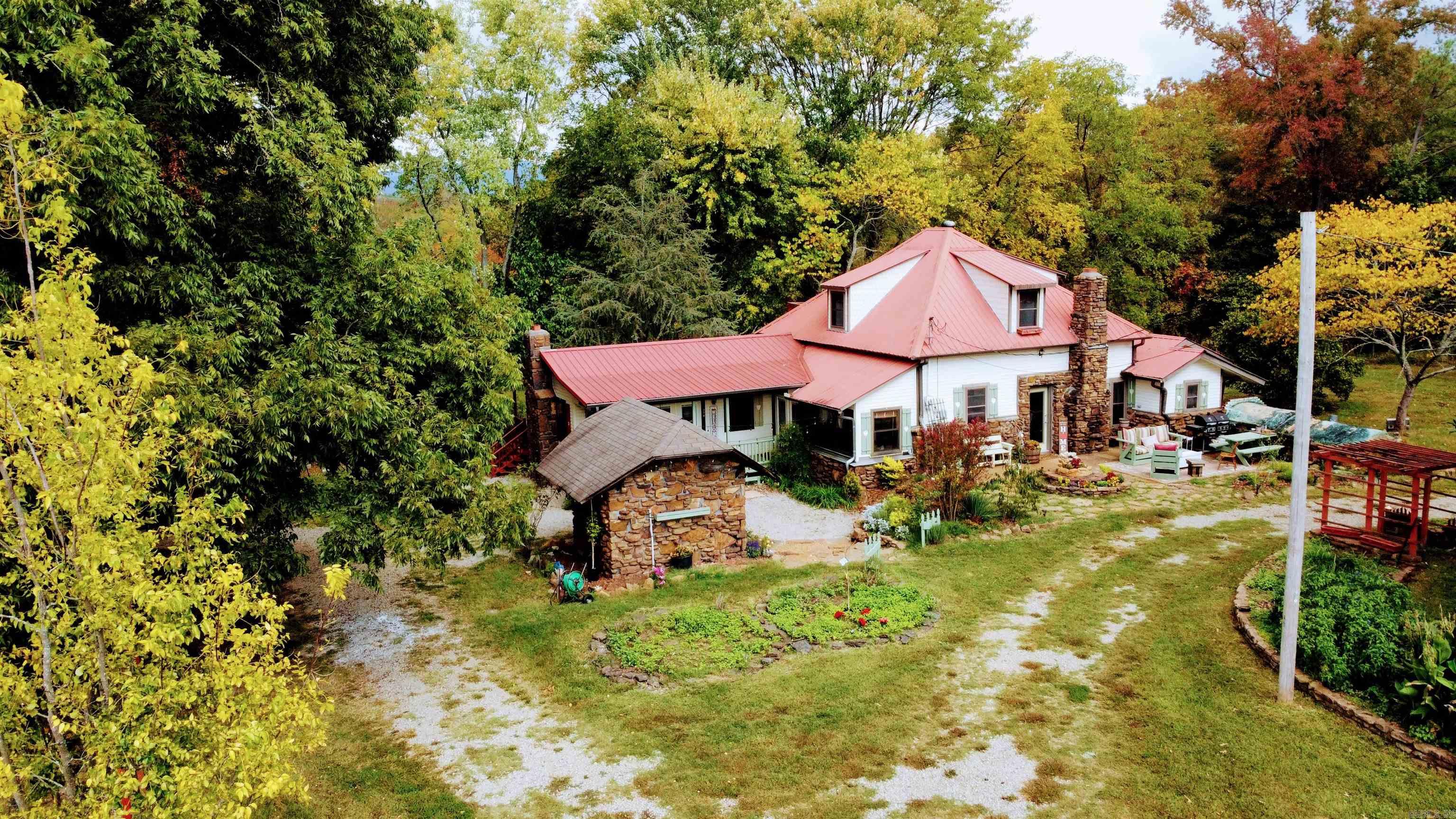 Nestled in the serene Ozark Mountains, this 39.50-acre hobby farm is a natural paradise. Fenced and cross-fenced, it features a stocked pond, perfect for bass, crappie, and bluegill fishing, as well as a spring-fed creek. Greenhouses, a barn, a well with irrigation, and a fenced vegetable garden await your farming ambitions. Abundant wildlife makes it a haven for hunters. Plus, there's a small building for guests. The income-producing hay fields and lush orchard offer pecan, apple, pear, plum, persimmon, chestnut trees, and more, creating a year-round bounty. The 2-story home boasts a newly updated kitchen with KitchenAid appliances and a deep farmhouse granite sink, while two custom soapstone fireplaces provide warmth. A storm shelter ensures safety. With tall/vaulted ceilings, a brand-new primary bedroom bathroom, and easy access to the national forest and nearby towns, this property offers a tranquil yet convenient lifestyle. Schedule a viewing today to embrace this enchanting and self-sufficient oasis.