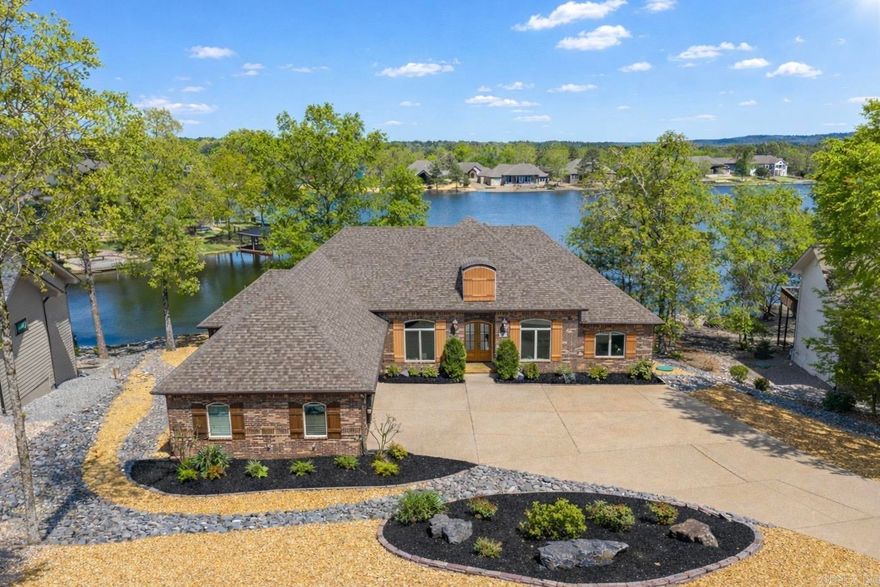 Experience lakefront living in Hot Springs Village with this all-brick, single-story home offering open-concept design, volume ceilings, and tranquil views of Lake Maria with direct access to a private swim/boat dock (2023). The custom kitchen features rustic cherry cabinetry, abundant storage, expansive pantry space, and extensive crown molding throughout, flowing seamlessly into the living and dining areas—ideal for everyday living and entertaining. The oversized primary en-suite includes a jetted garden tub, tiled walk-in shower, and a large custom walk-in closet with built-ins, conveniently connected to the laundry room. Enjoy outdoor living on the covered deck with piped-in gas for grilling overlooking the water. Additional highlights include new roof (2023), walk-up floored attic with bonus potential, and instant hot water system. Surrounded by multiple golf courses and located near HSV East Gate there’s quick access to medical, dining, pickleball, and daily conveniences. 3 bedrooms plus office or optional 4th bedroom. Furniture, golf cart, and water toys negotiable.