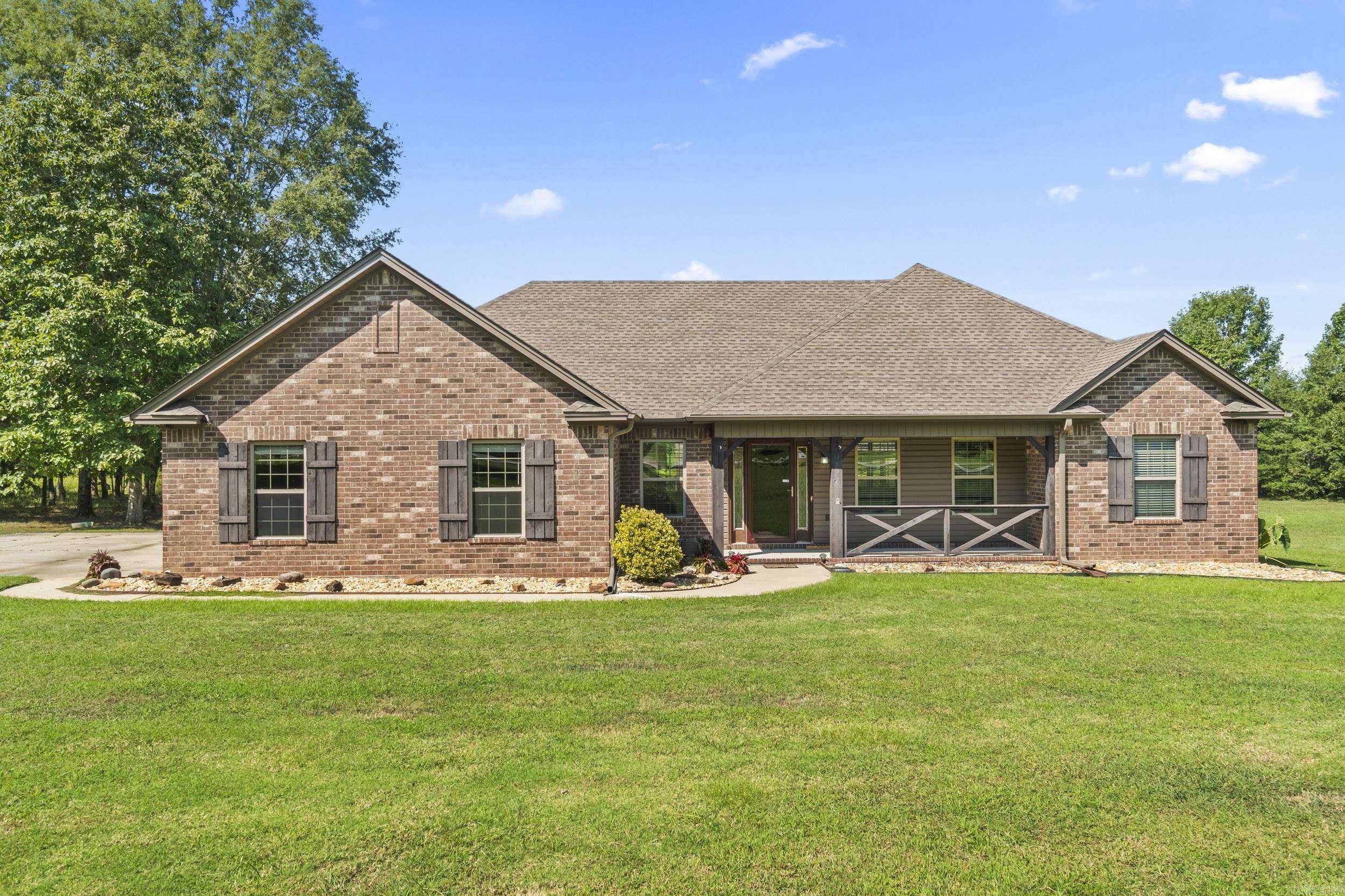 The complete package you've been waiting for! Set on 3.45 acres, this custom-built home brings modern comfort, functional design, and country charm into one gorgeous property. The home features 3 spacious bedrooms and 2 bathrooms, each designed with oversized closets and plenty of storage throughout. The inviting living room makes a statement with gorgeous wood beams and a cozy gas fireplace, while the sunroom is filled with natural light... so perfect for snuggling up to read a good book. This home features a split floor plan with a very nice kitchen! The primary suite includes a massive walk-in closet and a luxurious bathroom with a large soaking tub, walk-in shower, make-up vanity, and dual vanity. Also, this property offers a large 2-car garage with storage/tool area, a safe room and security system to provide peace of mind, a generator to ensure you're always prepared, and having fiber internet is a plus! Outside, you'll discover outdoor living at its finest, which offers a covered back patio with a wood burning fireplace, 30x50 shop with electricity, carport for an RV/RV hook-up, an additional carport, and even a deer stand conveys! Roof(2016) Mineral rights do not convey.