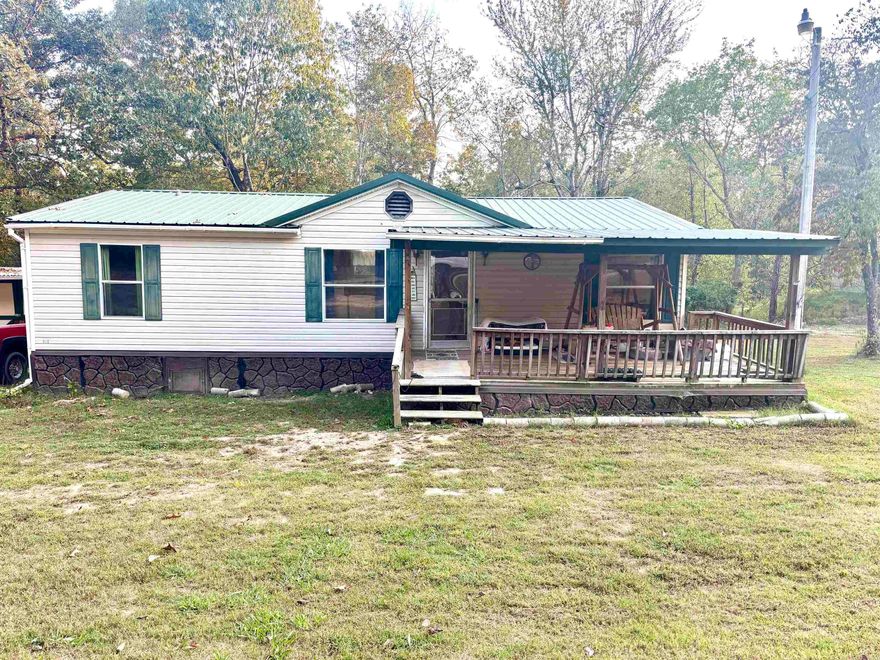 Quiet country living on a dead end street is what you will get with this 1996 double wide manufactured home. With 3 bedrooms and 2 baths on 3 lots you will have enough room to spread out with a split floor plan. Perfect for full time living or your lake home retreat! Just a few miles from Cranfield and Buzzard Roost and Norfork Marinas!! Outbuilding can be used for a workshop, storage or garage. Propane tank leased. NEXT internet available. Water connection and septic installed for RV parking. Minutes to shopping, restaurants and hospital. Seller has priced for a quick sale and ready to move! Don’t miss it!!! Title Ins is obtainable.