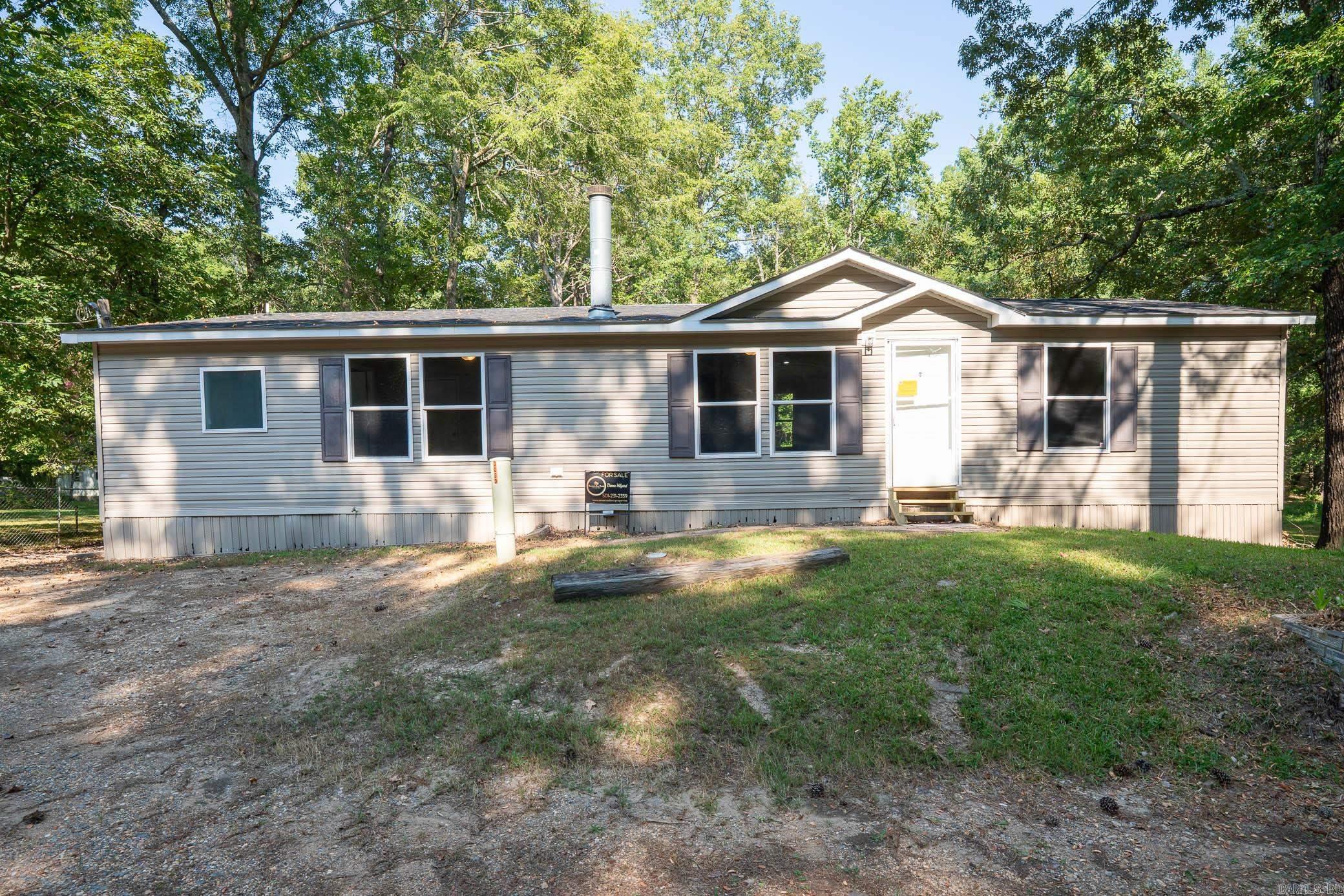 Welcome to your dream home on 3.2 acres of picturesque, wooded land! This stunning home offers a perfect blend of comfort and style, featuring 3 spacious bedrooms and 2 sparkling bathrooms. Step inside to discover a generous living space that includes an enormous kitchen and laundry room, designed for both functionality and ease. The kitchen and dining areas showcase brand new cabinet doors and fresh paint, creating a bright and inviting atmosphere. Enjoy meals in the charming breakfast nook or envision a custom-installed island to enhance your culinary experience. This home is filled with upgrades, including a brand new roof, updated heating and air system, and luxury vinyl plank flooring throughout. The decorative wood-burning fireplace and stylish trim add warmth and character to this beautiful space. Conveniently located with easy access to Interstate 530, this home offers a serene escape while remaining close to all the amenities you need. FHA and Rural Development financing options are available with an approved home application. Donāt miss this incredible opportunityāschedule your showing today and step into your new lifestyle!