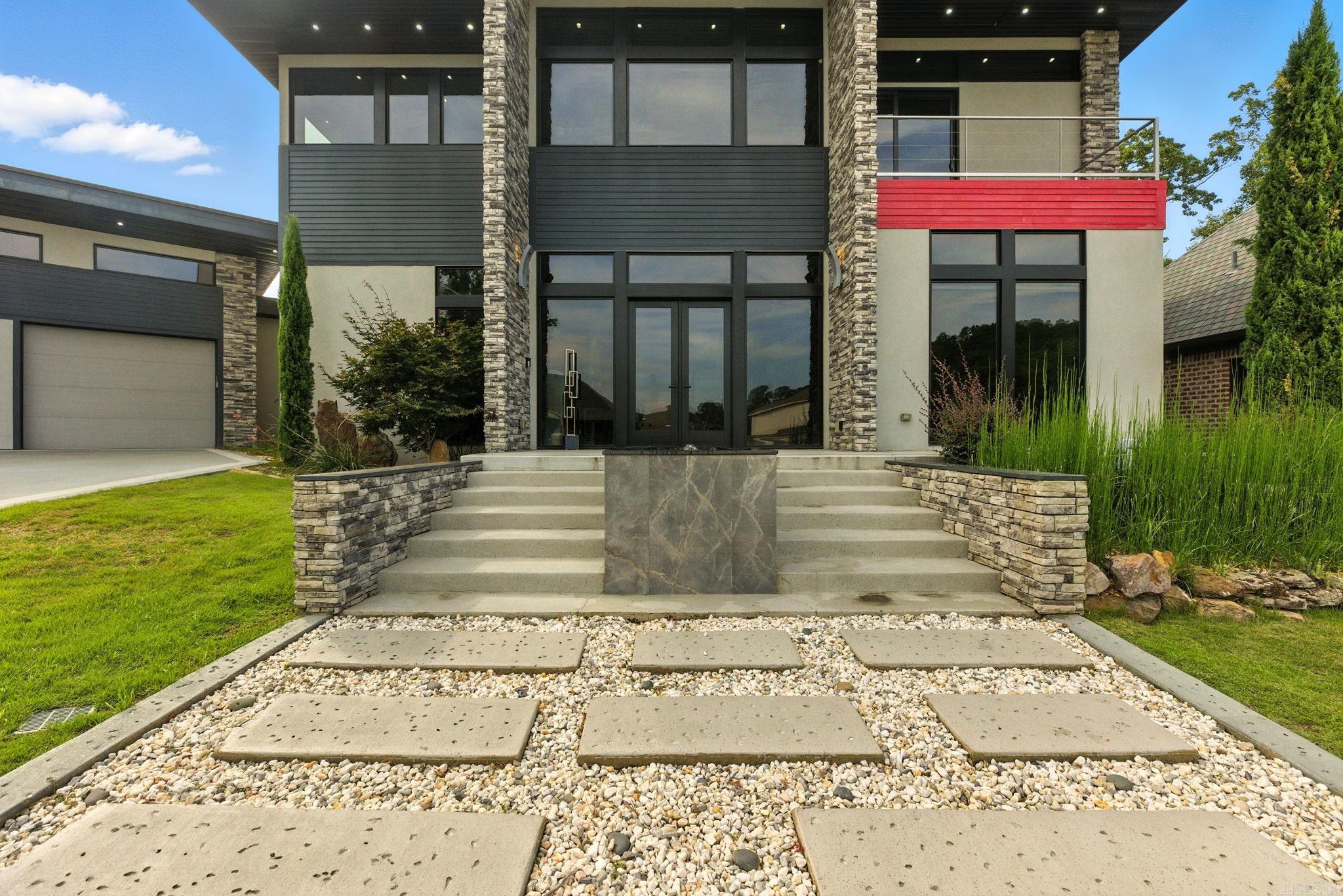 31 La Scala Court is a modern masterpiece where stone, metal, and glass converge in flawless harmony. A striking fountain sets the stage for the double-door entry, opening to soaring ceilings and walls of glass. At the heart of the home, a chef’s kitchen showcases a 17-foot waterfall island, sleek custom cabinetry, and integrated appliances. A stunning custom staircase rises to a versatile bonus room and two guest suites connected by a unique shared suite bath with private vanities and toilets. The owner’s suite is a retreat unto itself with a cozy sitting area, office nook, and a spa-worthy bath overlooking the serene backyard water feature. The boutique-style custom closet connects seamlessly to the laundry room for convenience and ease. Every inch reflects exquisite attention to detail, from dramatic architectural elements to thoughtful design choices. Set on a premier lot in a gated cul-de-sac, this residence is offered for the first time ever. This is an unparalleled opportunity to own a work of art that embodies modern luxury and timeless design. For those who demand the extraordinary, this is the home that defines it.