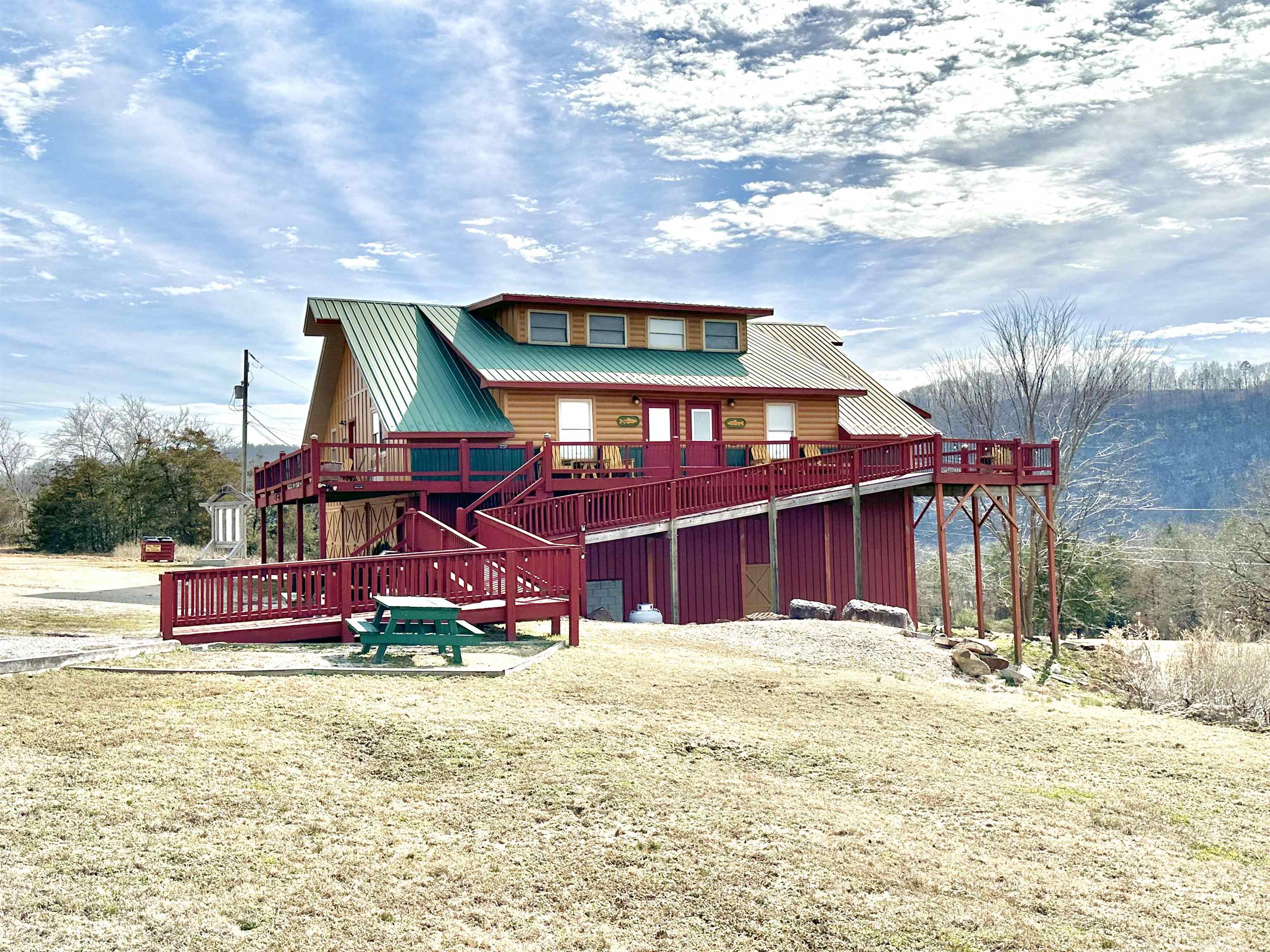 FULLY FURNISHED FISH TALES LODGE is available to purchase!! This property offers an amazing view of the mountains and is located minutes from the famous White River, Sylamore Creeks, & Downtown Mountain View! It is currently being used as a nightly Vacation Rental but has endless possibilities. It features 4 identical units all on one floor with handicap accessibility and a private entrance to each! Each unit has an open kitchen/ living area, bedroom, 1 bathroom, plus an open loft serving as an additional bedroom as well as access to a shared laundry room. Below the units you will find tons of storage! 3 separate storage rooms as well as boat or RV storage! *All items will convey minus personal items, supplies, & items inside storage rooms*