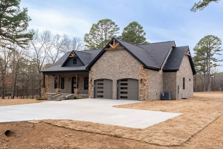 New construction home located in one of Heber Springs’ premier neighborhoods. Built by a proven local builder known for superior quality, attention to detail, and making standard what other builder charge extra for, this residence seamlessly blends timeless elegance with contemporary style. The exterior features a sophisticated mix of brick and stone wrapping around to a covered back porch with a beautiful tongue-and-groove wood ceiling-made to entertaining year-round. Step inside to vaulted ceilings with wood accents in the open living area, anchored by a stunning custom stone fireplace that creates an inviting focal point. Premium finishes elevate every space: custom cabinetry with high-end stains, designer lighting, and granite countertops throughout, including the gourmet kitchen with its large island and abundant storage. The master suite features a tray ceiling and a spa-inspired bathroom with a deep soaking tub, spacious walk-in shower, and an extraordinary walk-in closet with built-in organizers ample enough for even the most extensive wardrobe collection. From abundant natural light to large double garage, don’t miss out on the perfect place to call home.