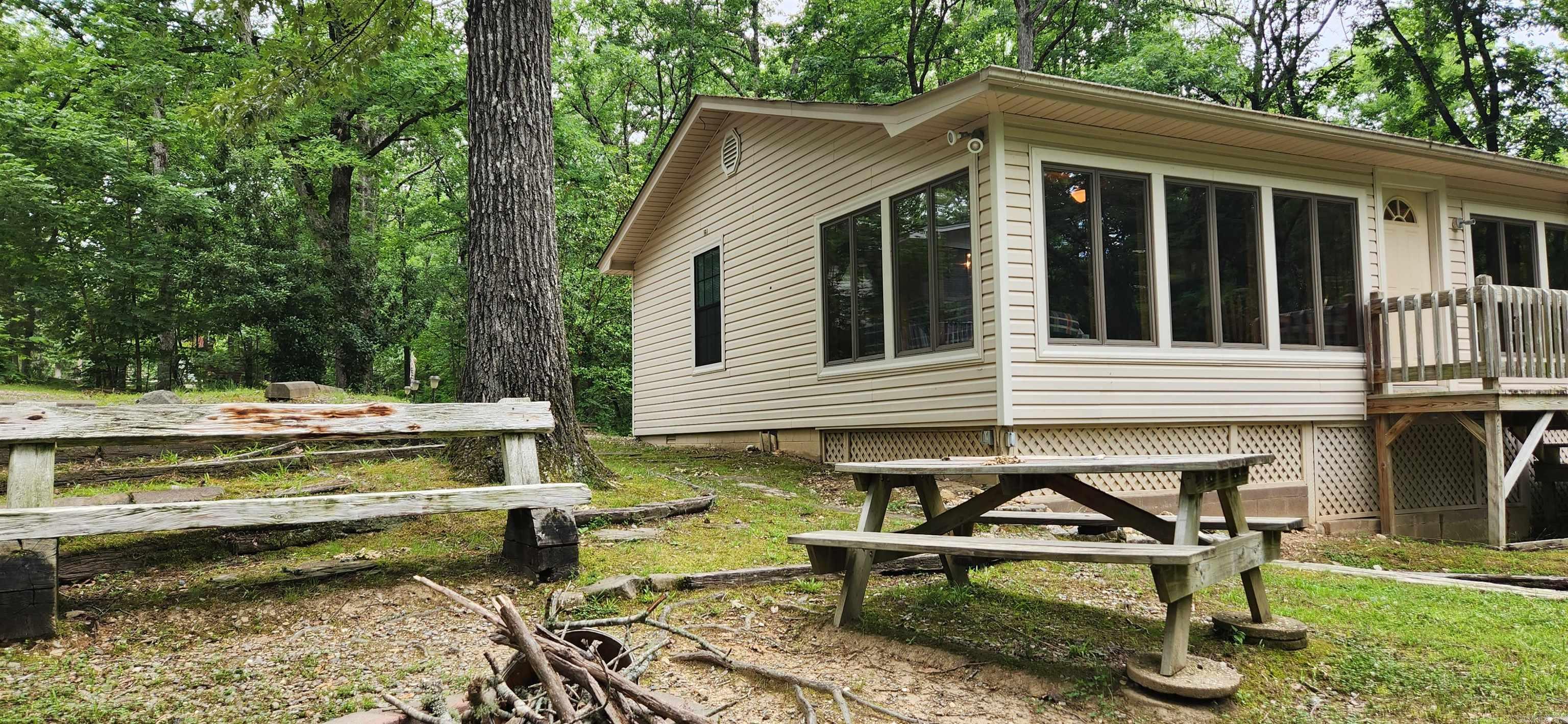 I truly love the sunroom on this house. It is 36x10 with lots of windows. Tucked away in a quiet area not far from Lake Ouachita is this 1.42 acre tract with a 1808 sq ft 2 bedroom, 2 bath, has lots of space. City water. Currently used as a vacation rental (all current bookings convey with the purchase and has been in business for over 7 years) it also comes furnished. 24x28 carport with 3 bays of storage, wooden deck, 10x16 bunkhouse and lots of room to make memories. Nice stand of hardwood trees. Whether used as a lake house or an investment, you truly can not go wrong with this. No restrictions.