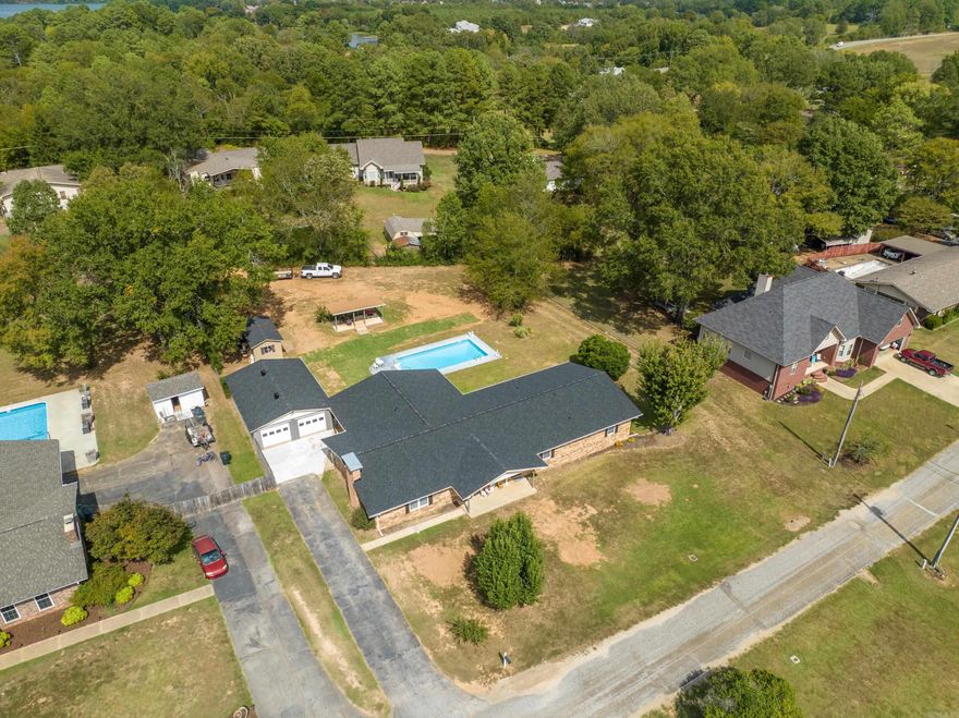 This one-level brick beauty is located in a quaint neighborhood in Lakeside School District. The 3/4 acre lot offers an in-ground pool (new liner 2021), a 24X36 detached garage/shop with overhead doors, a 10X20 storage shop, and a separate covered patio with ceiling fans to cool off by the pool. Inside the home, you'll appreciate the spacious floor plan featuring 4 bedrooms, 2.5 baths, wood-look tile floors, a separate theater/family room, and a peaceful Arkansas room to soak up the back yard views. The kitchen boasts gorgeous custom cabinetry, a wall oven with warming drawer beneath, and a built-in desk.