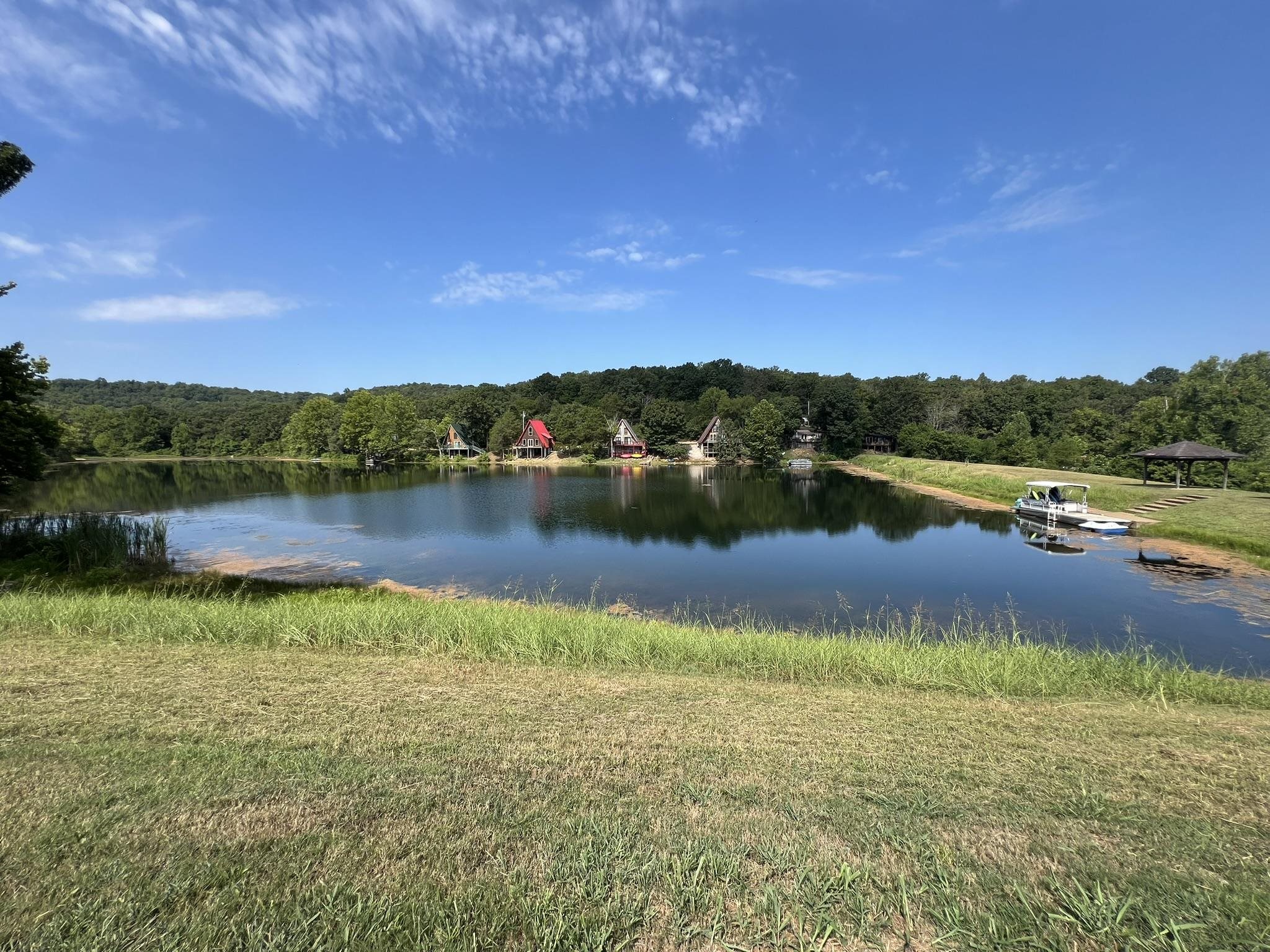 Recreational Property with frontage on Kiwanie Lake, formerly known as Lake Galilee. Potential RV Park/Air BnB cabins or build your dream home it is currently used as a private retreat. The 5.44 acres of land is serviced by Entergy Electric and 2 Highland water meters. There are 15 camper pads (10x20), 3 have 50 AMP service, 7 have 30 AMP service, 3 have septic risers and there is a dump station near the 2022 installed septic system. Two frost free hydrants, set such that they can serve multiple pads, 3 Pavilions and a pontoon boat utilized as a floating dock. Park area also has 2 fenced tennis courts and a 20x40 in ground pool in need of some maintenance to be operational. This property is near but not in Cherokee Village, it has a Hardy AR address but is not in the city limits.