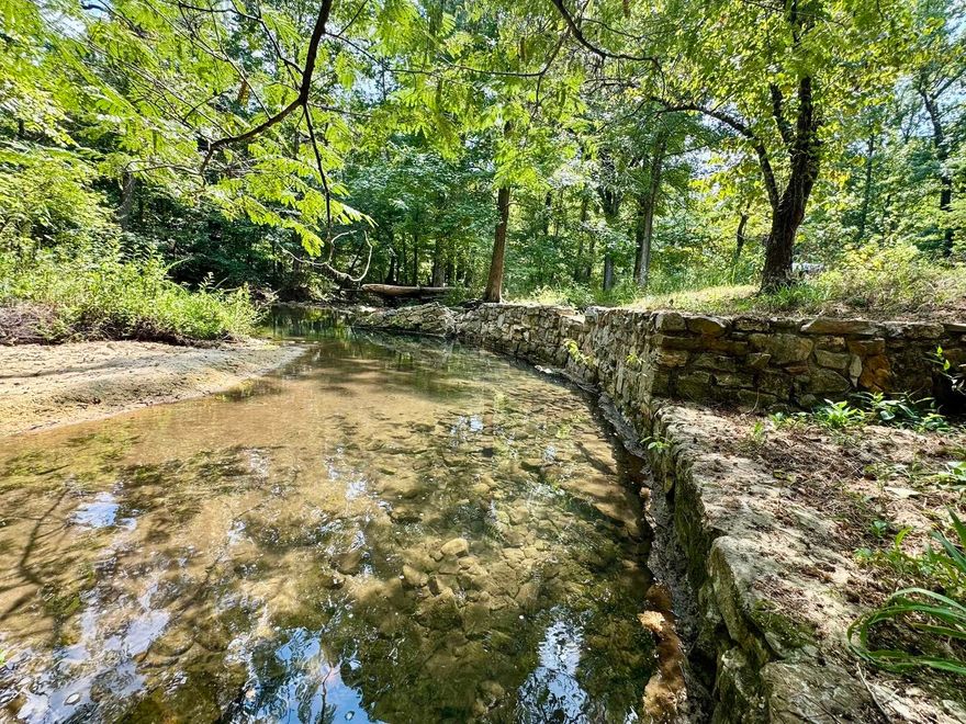 This 15.25 acre property offers endless potential with a beautiful year-round creek and a charming rock wall/patio area beside the water—perfect for relaxing or entertaining outdoors. The land is mostly wooded, offering privacy, natural beauty, and the option for subdivision or your own private retreat. There is power and an old well on the property, giving you a head start on your home or cabin.  Located just 1 mile from the White River and Downtown Calico Rock, you’ll enjoy both the peaceful seclusion of the Ozarks and the convenience of nearby shops, dining, and recreation. This property is a rare find with creek frontage, utilities in place, and endless possibilities!
