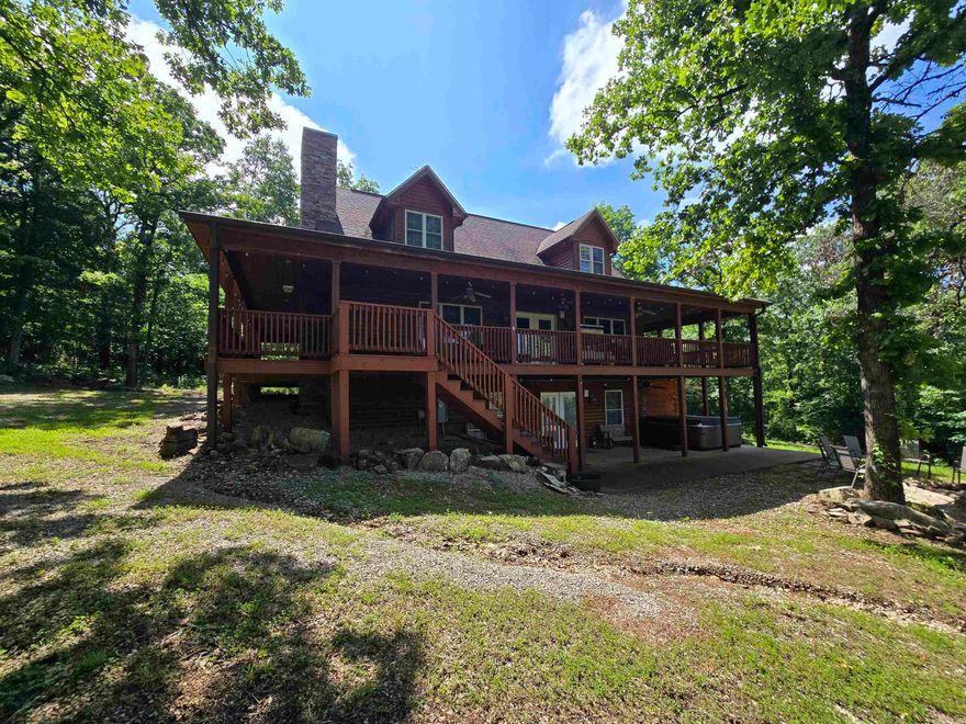 Escape to this stunning log-style retreat nestled on 20 acres m/l just minutes from White River & lake Norfork access. Offering the perfect mix of rustic charm and modern comfort, this property features soaring ceilings, warm wood finishes, a cozy fireplace, and an open living space designed for relaxing or entertaining. Enjoy breathtaking views from the covered wrap-around porch and gather around the fire pit under the stars. The fully finished walkout basement provides excellent additional living space for guests or family. A heated and cooled 40x40 shop with oversized doors offers endless possibilities for storage, hobbies, recreational equipment, or a workshop. Peaceful, private, and surrounded by abundant wildlife and natural beauty, this is the Ozarks getaway you’ve been waiting for. Listed at $599,900