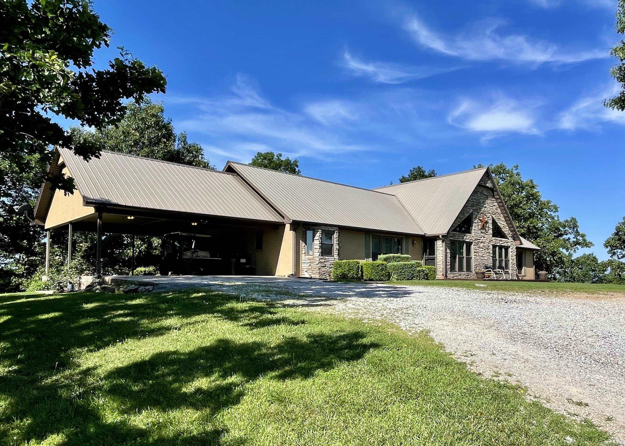 Perched atop the highest point in the county, this premier Ozark Mountain estate offers a rare combination of luxurious comfort, self-sufficient functionality, and breathtaking panoramic views. The custom-built 3-bedroom, 2-bathroom main residence spans 2,542 square feet, with expansive decks and covered porches that capture stunning sunrises, sunsets, and rolling green pastures from nearly every room. Every inch of this property has been thoughtfully maintained and masterfully developed.