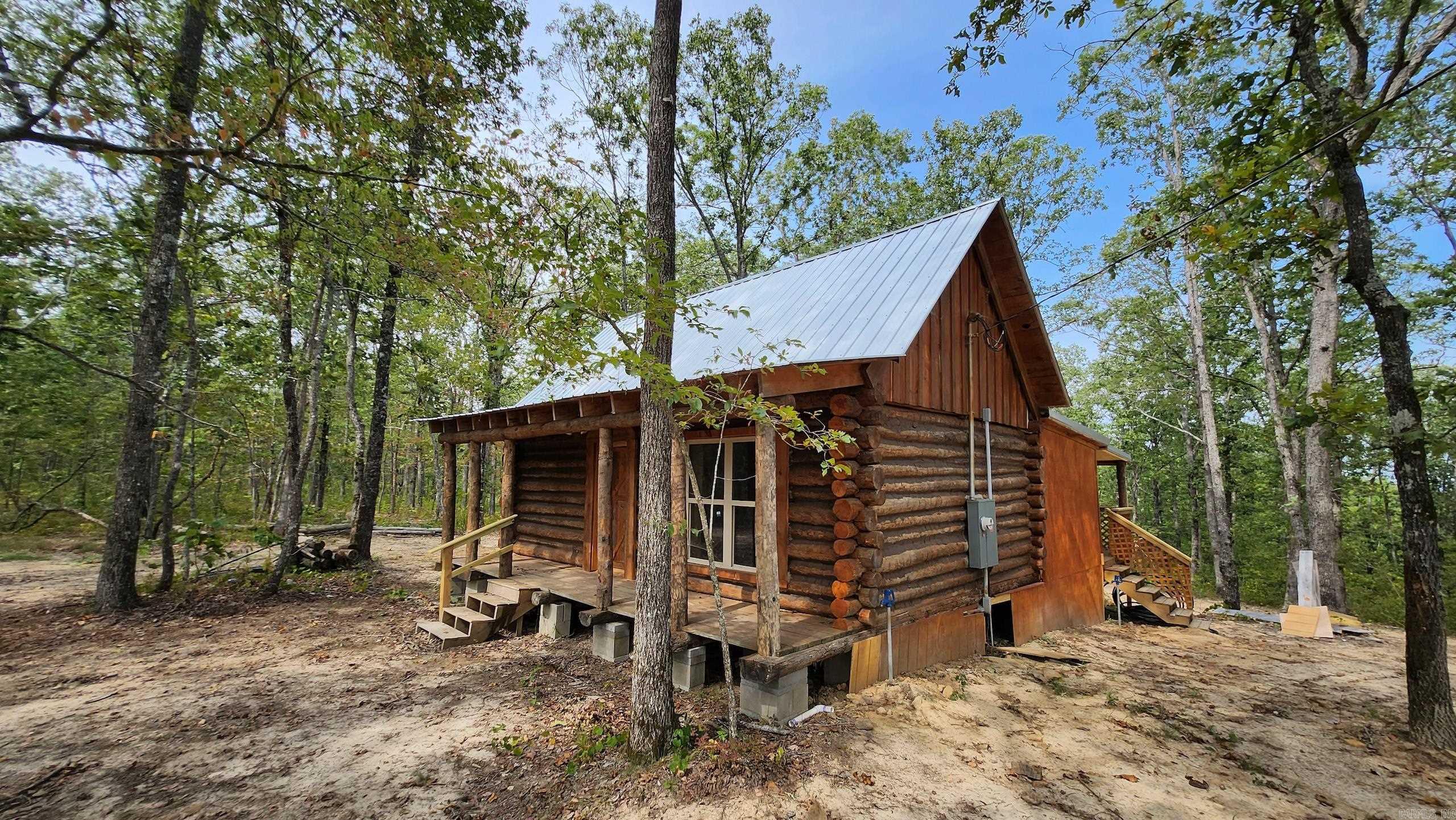The cabin on Big Piney is a stunning setting with a real log cabin setting amongst one whale of a stand of timber! As the name indicates, the mature marketable pine is plentiful and absolutely gorgeous. So many factors add up to create a superstar in this awesome property. As you enter on the well-maintained road, there is a newly dozed and grated road traveling all the way to the front porch of the quaint little cabin. The cabin features double-pane windows, aged logs, vintage doors, modern updates, a covered front porch, and even a loft! This spectacular cabin has recently been fully renovated, completed, and buttoned up neat as a pin. Sporting knotty pine walls and vaulted ceilings, you take a step back in time as you enter. The kitchen has new cabinets, a new sink, some appliances, and is fully plumbed. There are new vinyl plank floors throughout the entire cabin. A large addition has been added with a full bathroom, bedroom, and a massive covered back deck overlooking the beautiful wooded landscape. Electricity has been run to the cabin, a new well drilled and hooked up, along with new lights and fixtures⦠this place is ready to go!