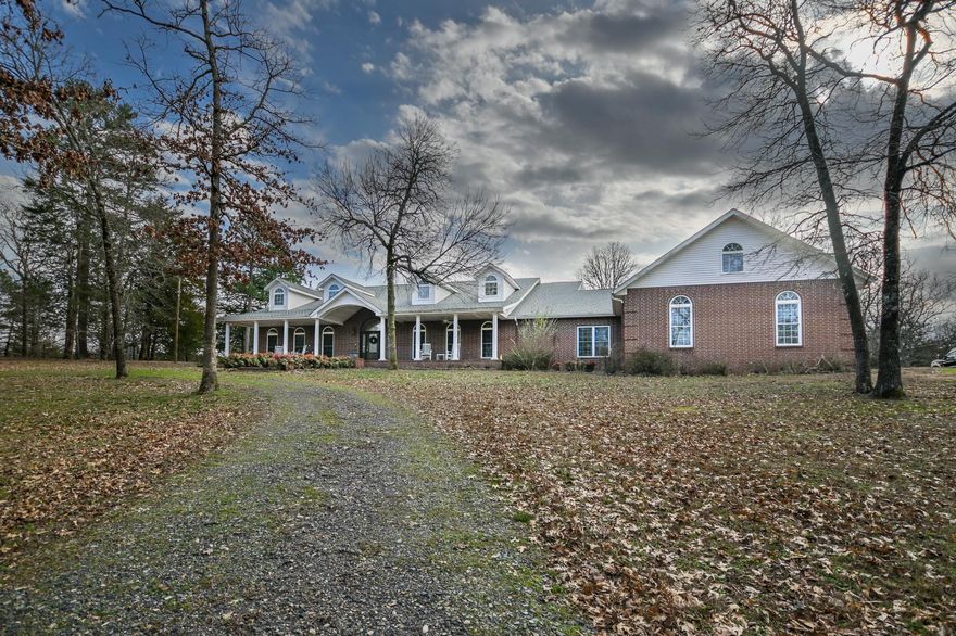 IMPECCABLE, GRANDEUR, EXQUISITE are a few words to describe this amazing home located in Mena, AR. Situated on 51.92 acres with Two Mile Creek (year around creek) bordering on the south side. Mature hardwoods all throughout the rolling hills of this property. Walk up to this beautiful home onto the magnificent front porch large enough for family reunions or weddings and then enter into the foyer featuring the elegance of a vaulted ceiling and chandelier. This lovely home features 2 ensuites and a primary bedroom that has the grandest of bathrooms with a wall of mirrors and a vanity for getting ready for that special occasion. Continuing with a great room, game room and a very spacious family room.  Kitchen features, granite countertops, detailed wood cabinetry, hidden spice racks on each side of the cooktop and a butler's pantry.  A home office at the end of the tour before going into the oversize 3 car garage. And to finish, there is a basement with storage and a garage door; perfect for lawnmowers, small cars or make it into a theatre. There is nothing this home does not have.  Agents see remarks.