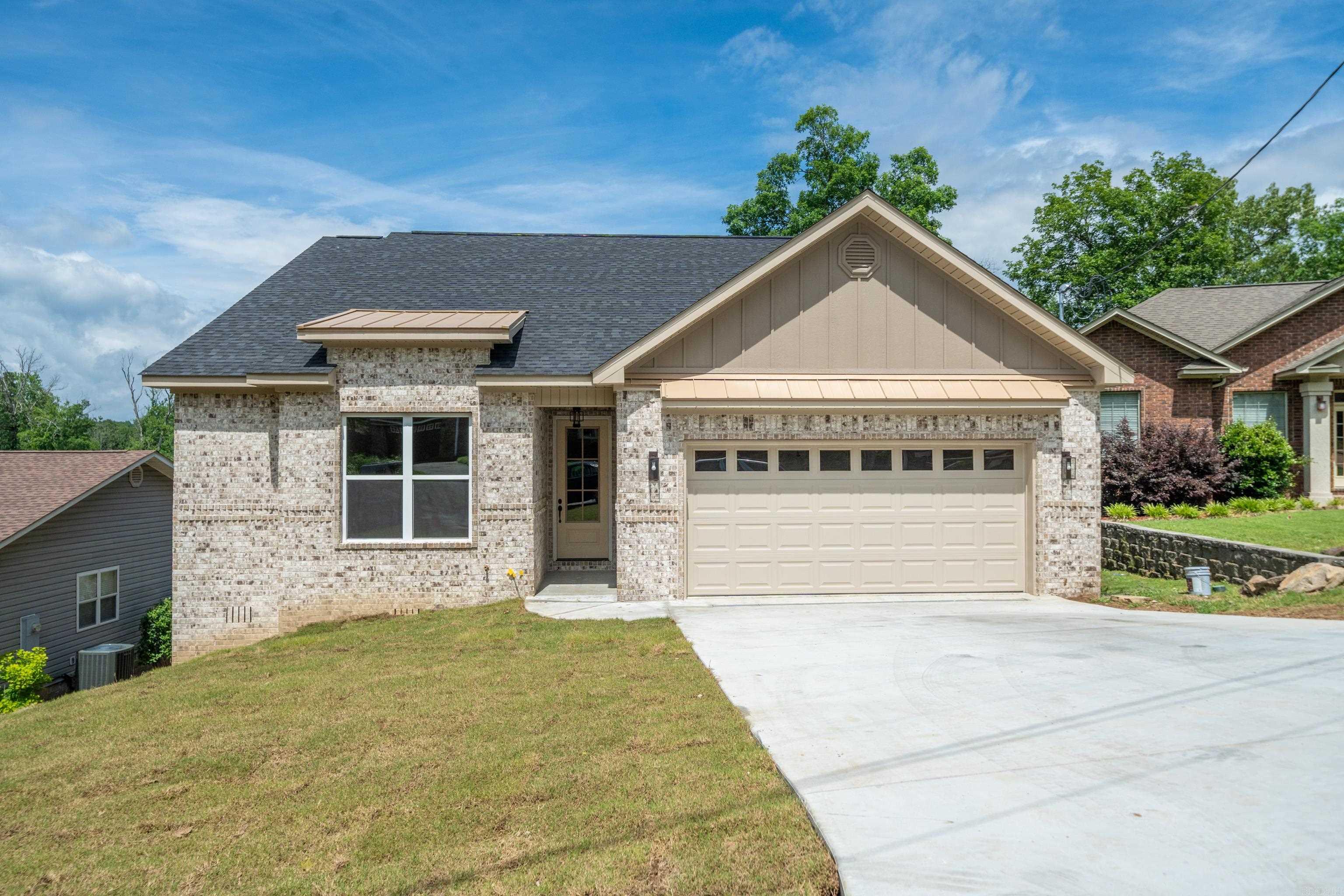 New Construction Lake Home. We have compiled several key elements distinguishing some of the most popular home design styles. These key features emphasize warmth, outdoor living, and a connection to nature. Earthy tones, natural materials, and an open floorplan enhance the seamless indoor-outdoor flow. The covered upper deck is a perfect extension of the home, spanning the full length of the house and accessible from the breakfast nook, the great room, and the primary suite. This design allows ample natural light to enter and provides a lake view. The covered lower deck also includes an outdoor kitchen and access to a walk-in basement storage area, ensuring easy access to the home's mechanical systems. The home has GE stainless steel appliances, including a dual-fuel range and a tankless gas water heater. The gas log starter fireplace is framed with stone and a wood mantel, allowing the natural flow to extend throughout the great room. The kitchen continues the flow with custom cabinetry, a wood-stained vent hood, and a large island covered with granite throughout.
