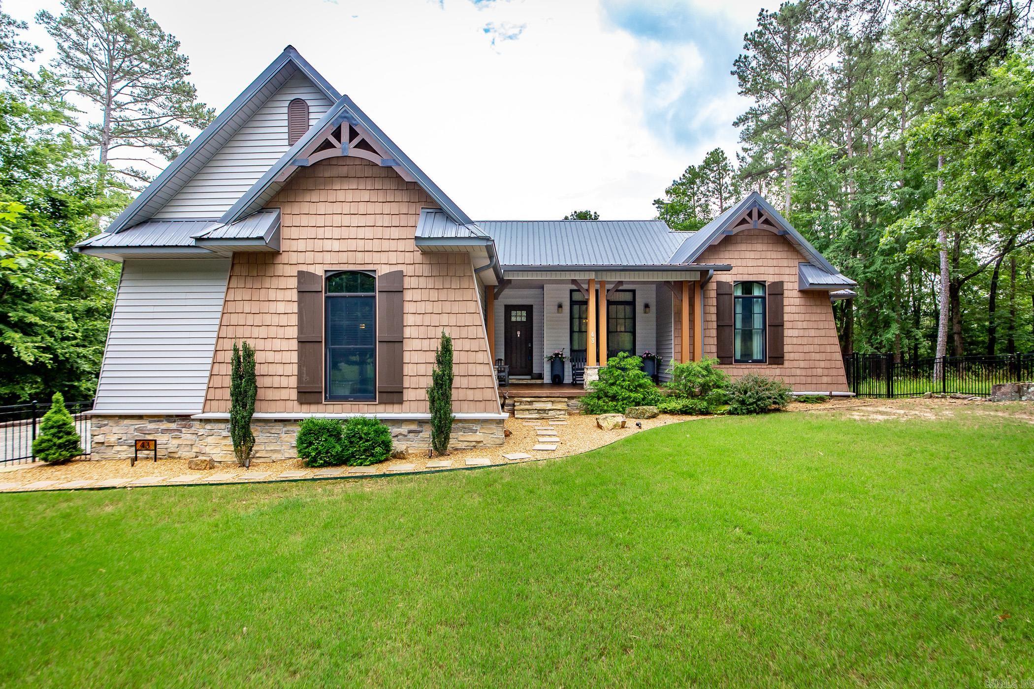 RIVERFRONT custom built home right on the river! This beauty is nestled in the woods with landscape lighting to set the relaxing mood and paved road to the dock. Custom fencing just installed and even a kennel under the deck for furry friends! Soak up the amazing open floor plan with huge kitchen accented with custom cabinetry, big breakfast bar with leathered granite and even a refrigerator with a built in keurig! Woohoo! High end GE Cafe appliances with convection oven. Primary suite will blow you away with all the room! Jack & Jill plan for kids and bonus room upstairs for game room or guests. So many improvements to make this your dream come true home! Whole home generator and metal roof, too! CUSTOM draperies and rods can stay with acceptable offer. All TVs will stay. Make your plans to fish or boat off your own dock with covered slip. Life is good on the river! See docs online for improvements, features, SPD etc.