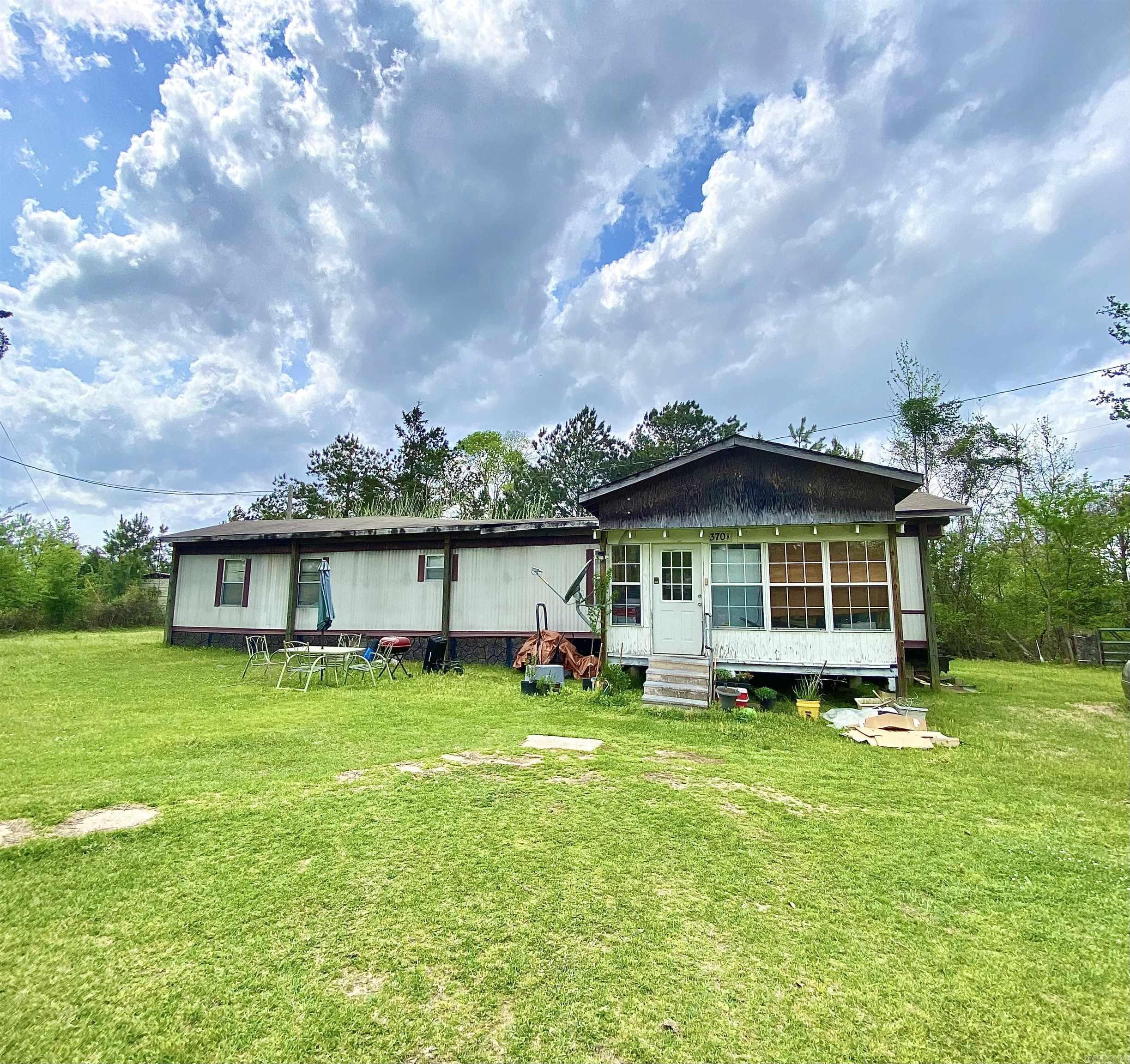 Looking for a peaceful home-place outside city limits? This 1999 manufactured home sits on 1 acre. With 3 bedrooms/2 bathroom, the home boasts an open living space with a large kitchen. A small storage building is also on the property.