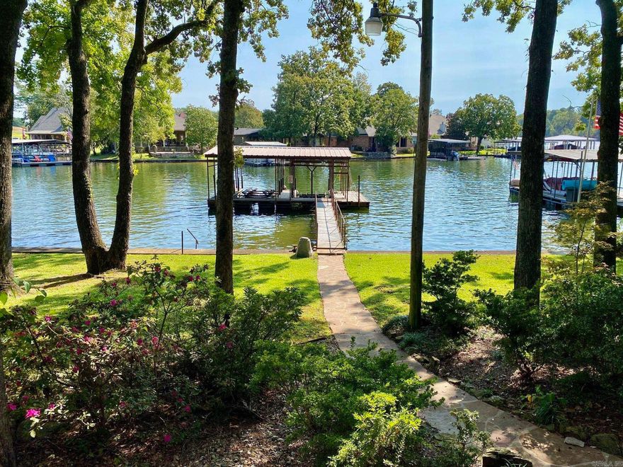 Check out this beautifully renovated home on Lake Hamilton! Situated on a level lot with stunning lake views. This 2 bedroom, 2.5bathroom, in 1,574sqf+/- includes a spacious back deck that's perfect for entertaining and enjoying the beautiful sunrise over the lake.Additional private deck off the primary bedroom with access to a hot tub. Floating two slip boat dock with lifts. Plenty of green space anda custom landscaped lawn to enjoy.