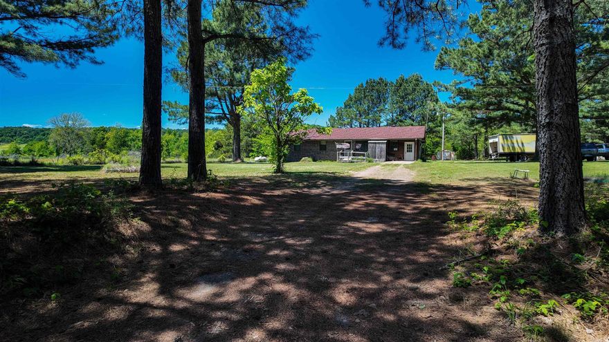 Charming country home situated on approximately 1 acre in the peaceful Center Ridge area! This one-level brick home offers rustic character throughout with warm wood accents, spacious living areas, a cozy fireplace, and a separate laundry room for added convenience. Originally a 3-bedroom home, one bedroom was combined to create an enlarged primary bedroom with additional space and comfort. Recent updates include a roof replacement and installation of a central HVAC system approximately 3 years ago. Enjoy relaxing mornings and evenings from the large covered porch overlooking the scenic rural setting. The property also features an attached storage/work area with concrete flooring, a storage building, concrete driveway, and plenty of outdoor space to enjoy country living while still being conveniently located to surrounding communities.