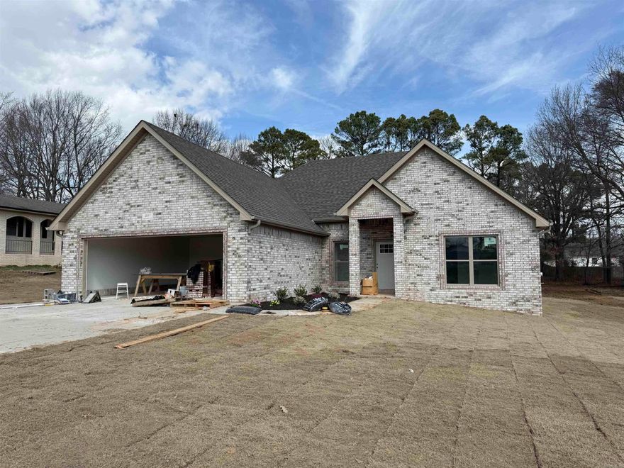 This beautiful new construction home offers the perfect opportunity for buyers to add their own personal touches while it is still under construction. Located in the growing area in South Paragould, this all brick home will feature three spacious bedrooms and a thoughtfully designed split bedroom floor plan that provides both comfort and privacy. The open concept layout creates a bright and inviting space ideal for everyday living and entertaining. The kitchen will showcase an oversized island, all custom cabinetry, elegant quartz countertops, and a convenient pantry for additional storage. Durable laminate wood flooring will run throughout the home, combining style with easy maintenance. The primary suite will include a walk in closet and a well designed layout for relaxation and comfort. Additional features include a dedicated laundry room and a double garage. Situated in a growing new subdivision, this home offers modern design, quality finishes, and the chance to make selections that truly make it your own.