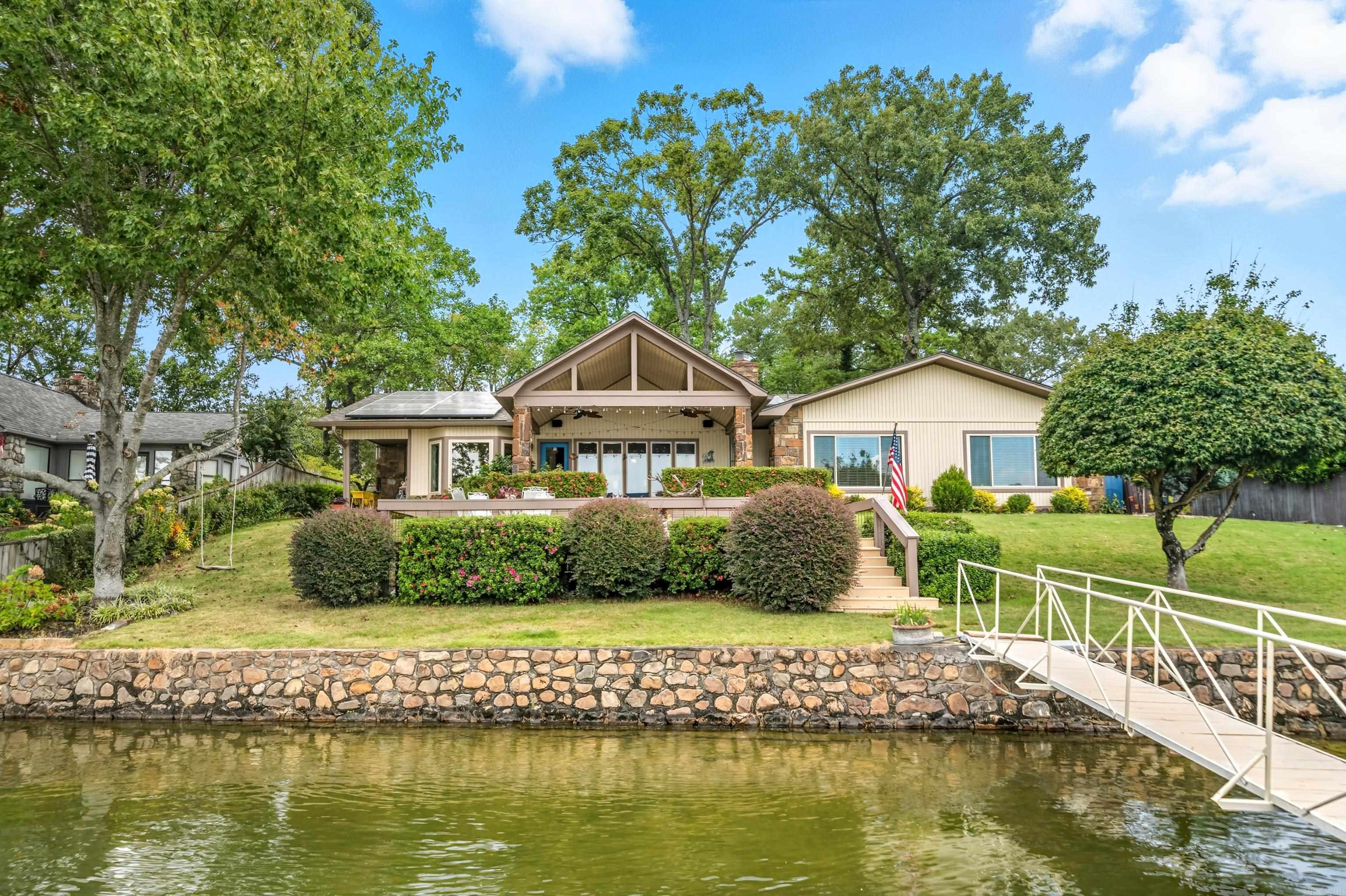 Turnkey Lakefront Living on Lake Hamilton Welcome to 110 Stately Point, a beautifully updated 4-bedroom, 3-bath home with 2,309 sq. ft. of living space on Lake Hamilton. This move-in ready property has every major update: Roof (2023), Windows (2023), Exterior Paint (2023), HVAC (2024), Water Heater (2020), Interior Paint (2021), and modern lighting. Inside, enjoy hand-scraped wood floors, fresh finishes, and updated bathrooms. The open-concept kitchen features a 2025 induction stove, 2023 refrigerator, and Frigidaire Gallery appliances, seamlessly connected to dining and living areas for easy entertaining. Bathrooms are stylish and functional, with quality fixtures and timeless appeal. Solar panels add efficiency and lower monthly expenses. Relax on the deck or in your living spaces with gorgeous Lake Hamilton views. Outdoors, a covered patio overlooks a scenic bay popular with boaters, and a double-stall boat dock offers direct water access. Perfect as a full-time residence or turnkey vacation retreat, 110 Stately Point has it all.