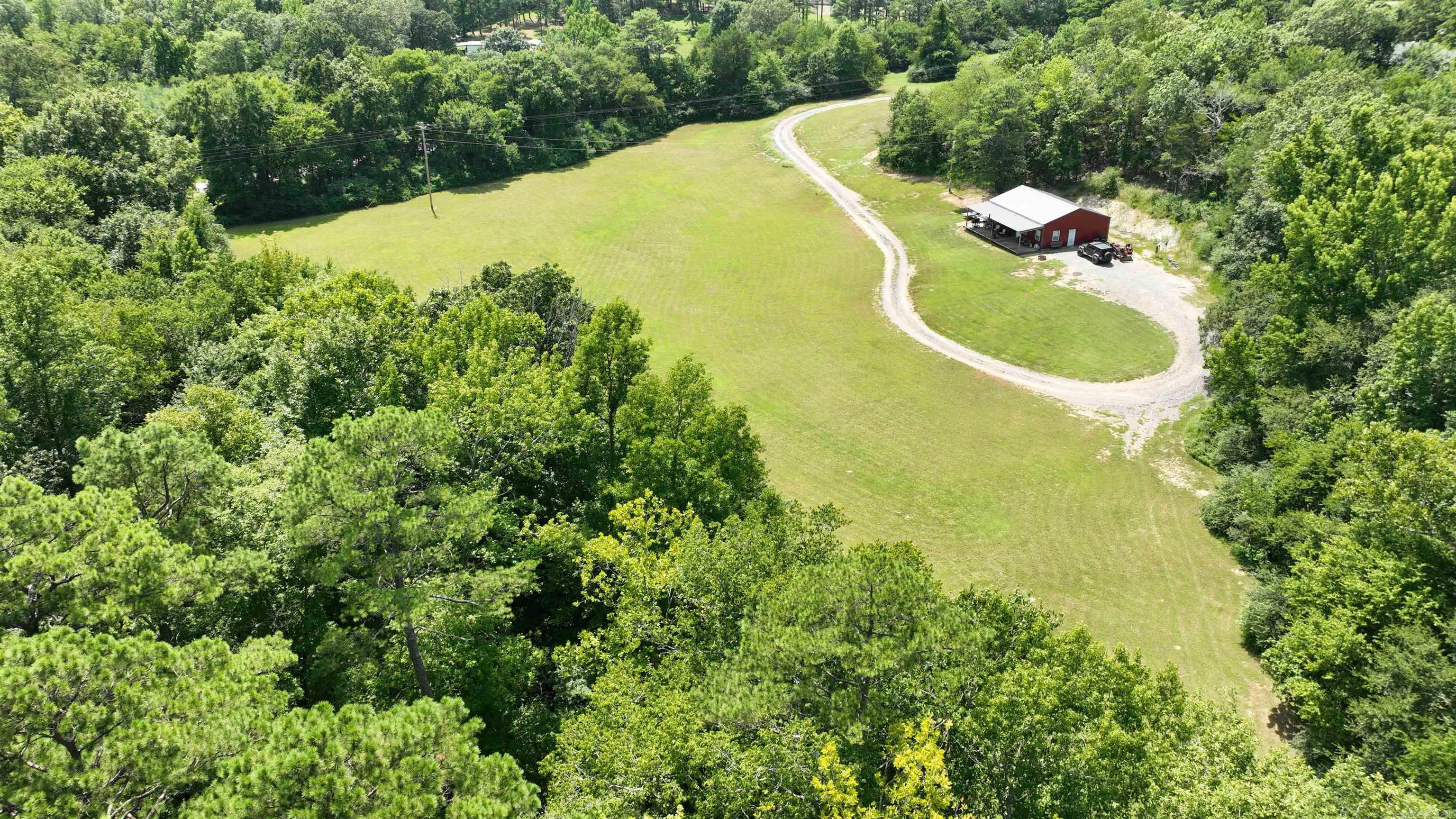 Escape to the perfect blend of rustic charm and modern living in this beautiful 2 bedroom, 2 bath barndominium-style home, built in 2021. Featuring an open-concept floor plan, this home is designed for both comfort and function, with central heat and air to keep you cozy year-round. Home needs some finishing. Step outside and take in the views from your full-length front porch, perfect for morning coffee or relaxing evenings. Nestled on 6.11 scenic acres with a creek, this property offers both peace and adventure. Home needs some finishing. Location, Location, Location! Just minutes from Mena, Arkansas. Close to Wolfpen Gap ATV Trails – a paradise for outdoor enthusiasts. Highway frontage. Whether you're looking for a weekend retreat, a forever home, or a vacation rental investment, this property has it all.