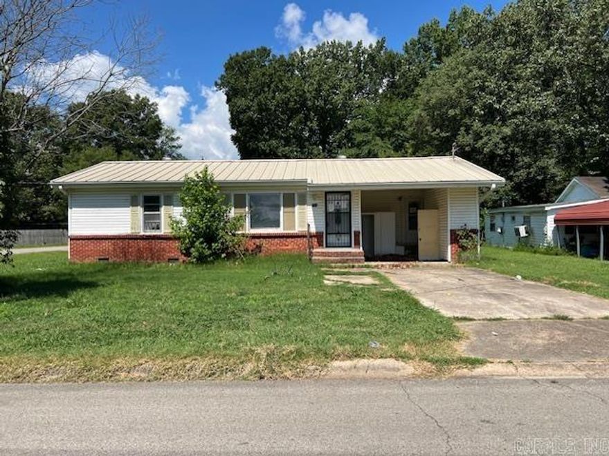 Vinyl and Brick ranch style home with a durable metal roof on a corner lot. Spacious two-car garage and a single carport all attached to the property. .21 acres of yard shaded by mature trees. There is a storm shelter for convenience. The interior has 1253 square feet of space with three bedrooms, 2 full bathrooms, a laundry room and a storage room. **agents please see showing remarks and agent remarks.**