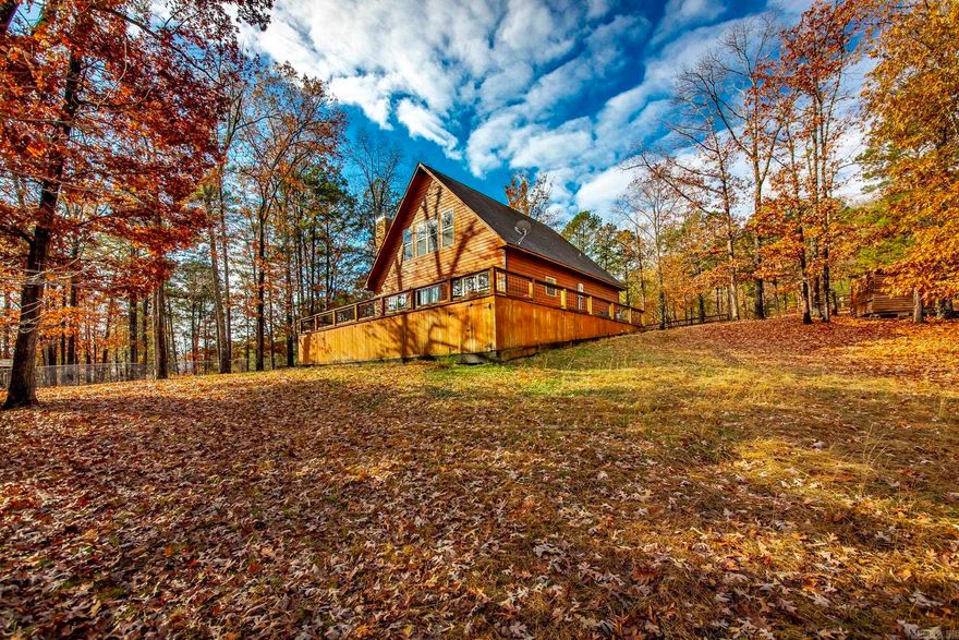 Two story cabin sitting on a little over an acre of land with 2 bedrooms on main level w/1 full bath and upstairs has a large bedroom w/vaulted ceilings & a full bath.  Gated driveway , wrap-around deck, stained concrete floors on main level , Breakfast bar in kitchen w/appliances that stay (refrigerator, oven, & microwave).  Cabin is located in Cove Creek so only about 2.3 miles from the Cove Creek Recreation Swimming Area & Boat Ramp.