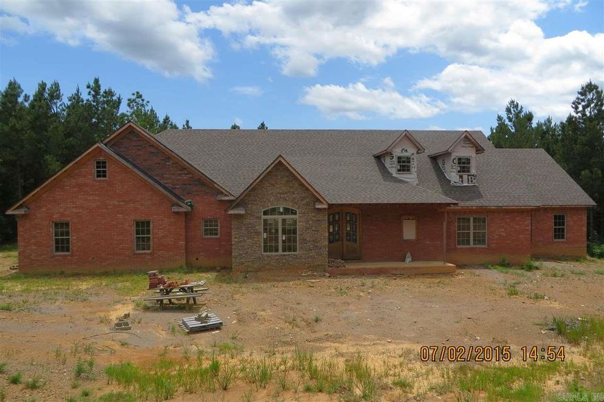 Over 3,600 sq ft mansion on almost 10 acres within min to Conway and Little Rock. Fabulous stained concrete floors, 2 staircases, rich crown molding throughout, designer kit cab, partially finished home can be your dream. 2 car gar AND 2 car shop/gar complete with full bath and W/D conn. This is a bank foreclosure that people can only dream of.  Finish the job and pick out all your own appliances, paint, and counter tops.  Live in the det gar/apt while you finish. NO Disclosures, NO warranty, implied or exp