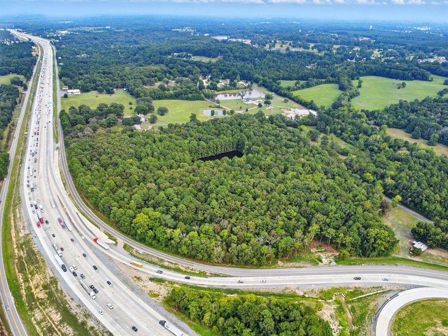 Approximately 24 acres with a pond located on the I-30 South frontage road, this property is ready for your development whether it is commercial or residential. Located in the county, this property has not restrictions and offers limitless possibilities. The area contains both residential properties as well as businesses and manufacturing companies. Located near the developments at the Highway 67 area where new schools, Buckee's and other construction is in progress, this is a prime location for your new or existing business to expand. Call your agent or me to set up a private showing.