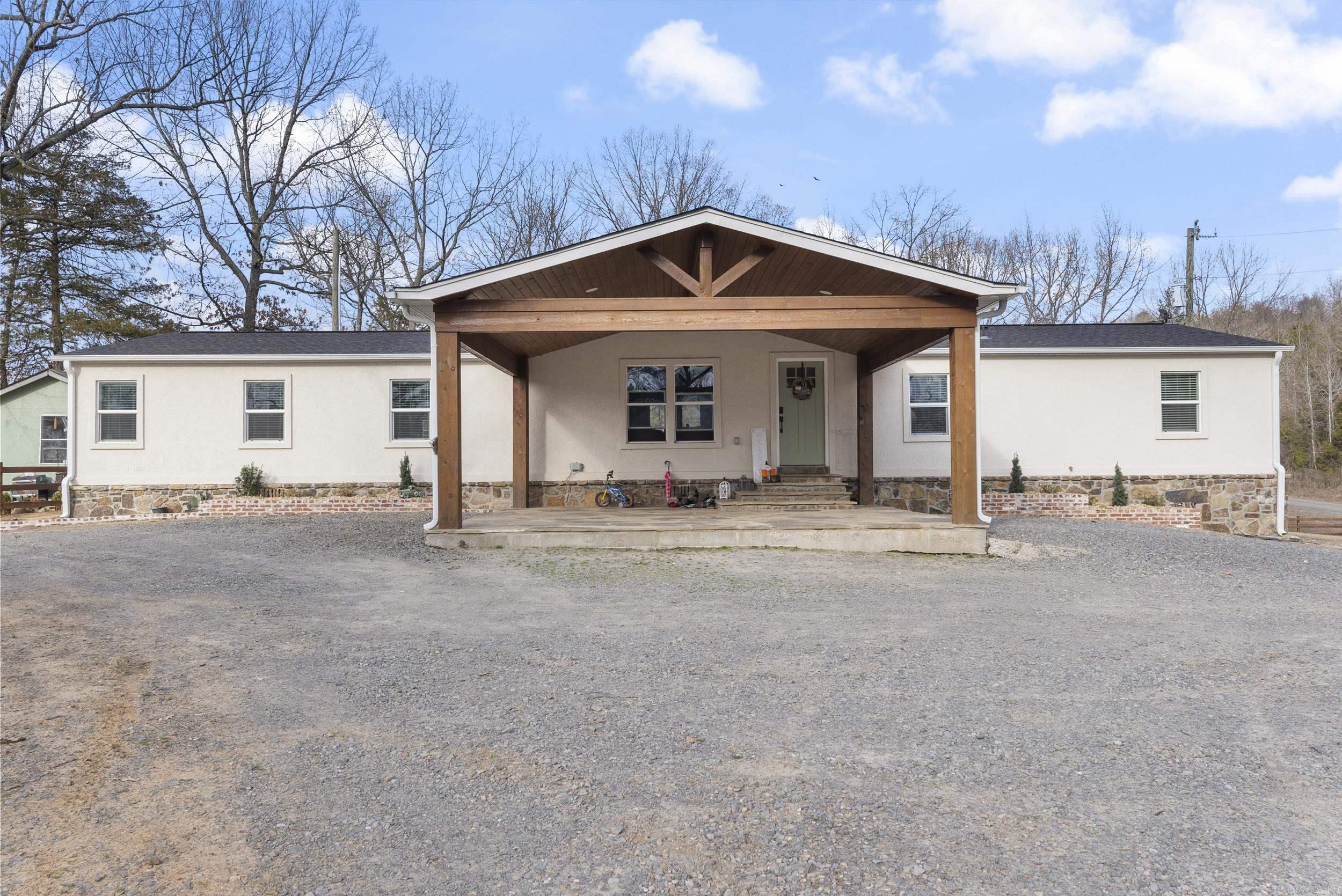 Completely remodeled 5-bedroom, 3-bath home on 1.13 acres on a permanent foundation, featuring tile flooring throughout, quartz countertops, stainless steel appliances, and custom cabinets. The master suite includes a double vanity and a tiled walk-in shower. A spacious concrete pad with water/sewer access offers great outdoor potential. The property includes a 28'0" x 22'9" shop with additional heated and cooled living space upstairs, perfect for a variety of uses. An attached 14'11" x 8'11" storm shelter adds extra security. Don't miss this incredible opportunity in a peaceful country setting! Agents see remarks.