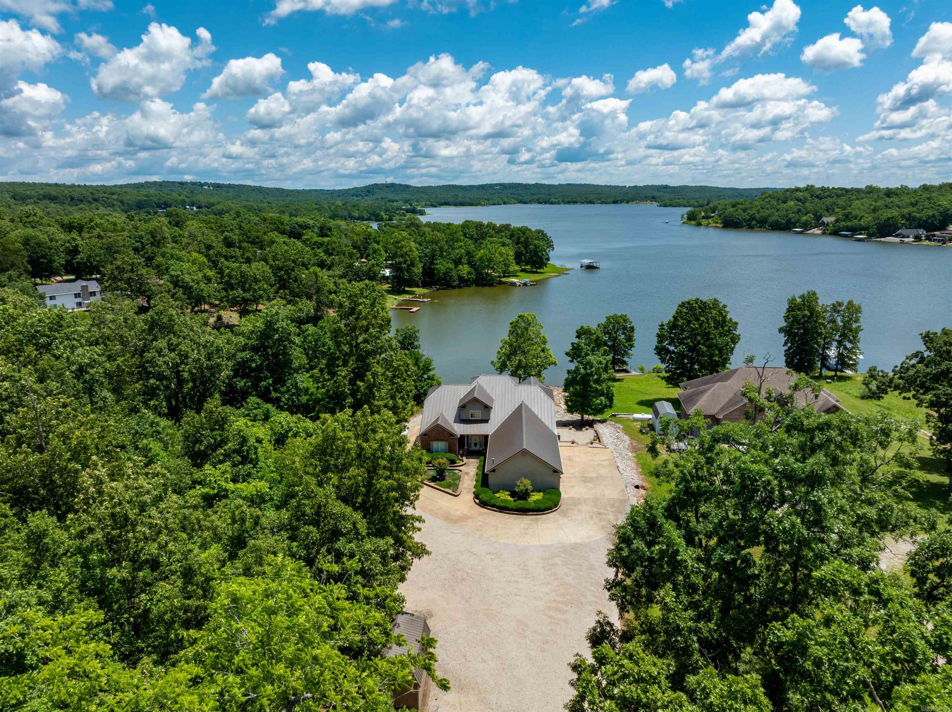 Stunning Waterfront Home on Crown Lake ā 4,200± Sq Ft, Move-In Ready! This beautiful 3 bed, 3 bath custom-built lakefront home offers approx. 2,100± sq ft on the main level and 2,100± sq ft finished walk-out basementāperfect for full-time living or a lake retreat. Enjoy panoramic Crown Lake views from soaring living room windows, vaulted ceilings, and a cozy fireplace. The kitchen features bar seating, a dining nook, and opens to a screened-in porch overlooking the lake. The main level includes an office or formal dining room(which ever a person decides to use it for), guest bedroom, full bath, and a spacious primary suite with bay windows, double closets, and ensuite bath. A large laundry/pantry leads to a covered carport and 3-car garage. Downstairs offers a massive rec room, bedroom, bath, kitchenette, and two oversized craft roomsāone ideal for a theater. Step outside to a covered patio, private boat dock, fire pit area, and low-maintenance landscaping. Bonus: Seller added a new furnace and heat pump in 2023. Located in peaceful Horseshoe Bend, AR, near golf, trails, and three lakes. Ready to move in and enjoy lake life!