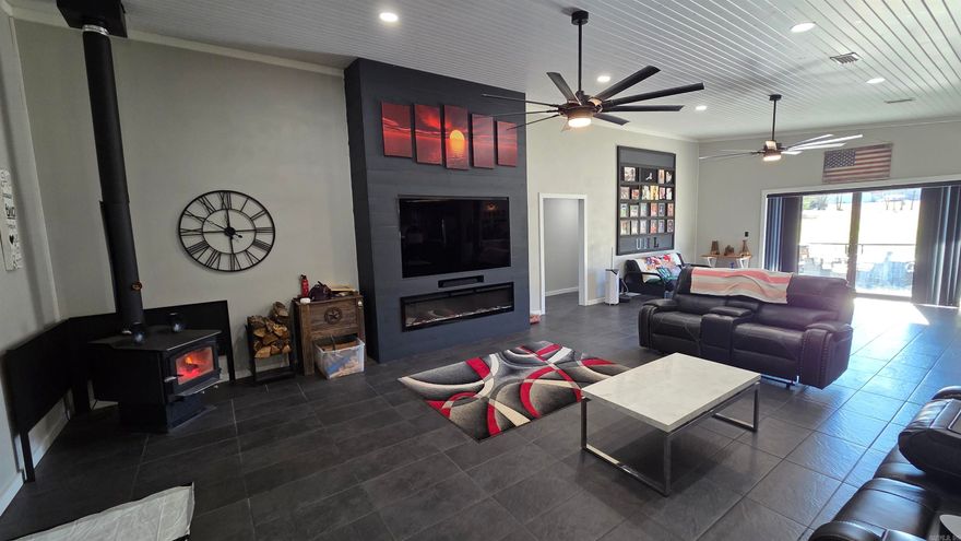 building 98' home inside 2023 Experience ultimate utility & luxury in this apprx 3100 sqft multi fam estate, featuring a 2,620 sqft heated & cooled custom home built entirely w-in a massive 6,600 sqft heated steel building. This unique property includes a year 1998-1280 sq ft, 3-bedroom sngle wide mobile home that conveys, along w dedicated RV electrical hookups. Inside the custom home, a versatile third room is ready for conversion into a third bdrm. The gourmet kitchen boasts high-end appliances, a full coffee bar, & built into the kitchen island granite countertops Invisacook brand, induction 2 burner cooktop, Custom lighting perfectly showcases your meals at the 10-person wooden table or the convenient breakfast bar. Stay cozy with both real wood and electric fireplaces, supported by a full HVAC system & a dedicated humidifier. The expansive master suite features a spa-like bathroom w dual 12" shower heads, twin handheld massagers, a sitting bench, & instant hot water. For the serious cook, the pantry includes a second stove, vent hood, butcher block, canning shelves, & room for a freezer. The massive shop is heated by a blown propane heater, & the vehicle lift is negotiable.