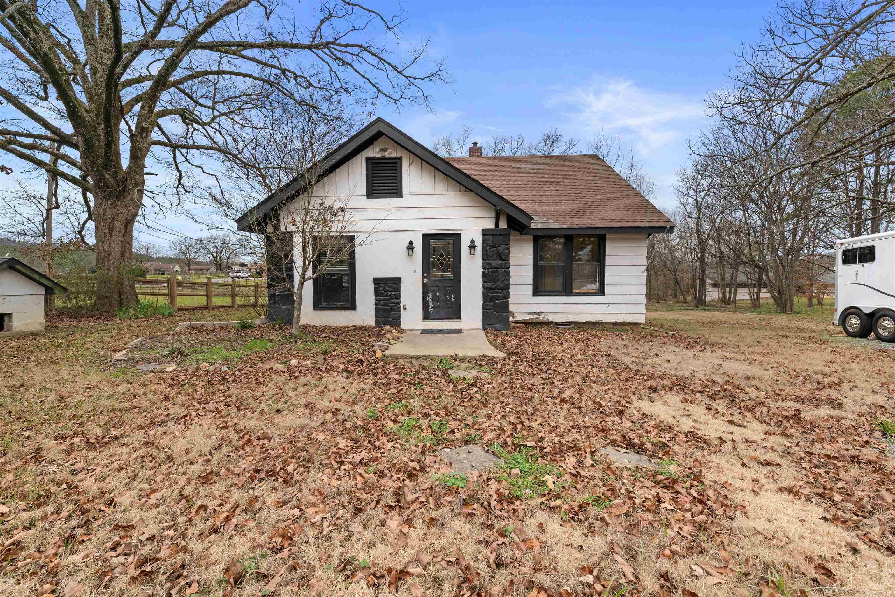 This charming country home, nestled on 2.14 acres of serene land, offers a perfect blend of rustic appeal and modern updates. The property is fully gated and fenced, providing both privacy and security, making it an ideal retreat. Inside, you'll find a spacious, open living room with beautiful tile floors, striking brick and stone accents, recessed lighting, and a cozy wood-burning fireplace—a perfect spot to relax or entertain. The dining area, featuring hardwood floors and a built-in buffet with extra storage. The updated kitchen is a standout, equipped with a refrigerator, flat surface stove, stainless steel microwave, and dishwasher, along with additional storage space to keep everything organized. Off the kitchen, enjoy a bright and airy sunroom which includes laundry hookups for added convenience. The home offers two bedrooms and a full bathroom on the main level. Upstairs, you'll find two additional bedrooms with walk-in closets, along with a half bath. Beyond the house, the acreage provides room for outdoor activities, gardening, or simply enjoying the land! Don’t miss this incredible opportunity, schedule a showing today and imagine the possibilities for your next home.