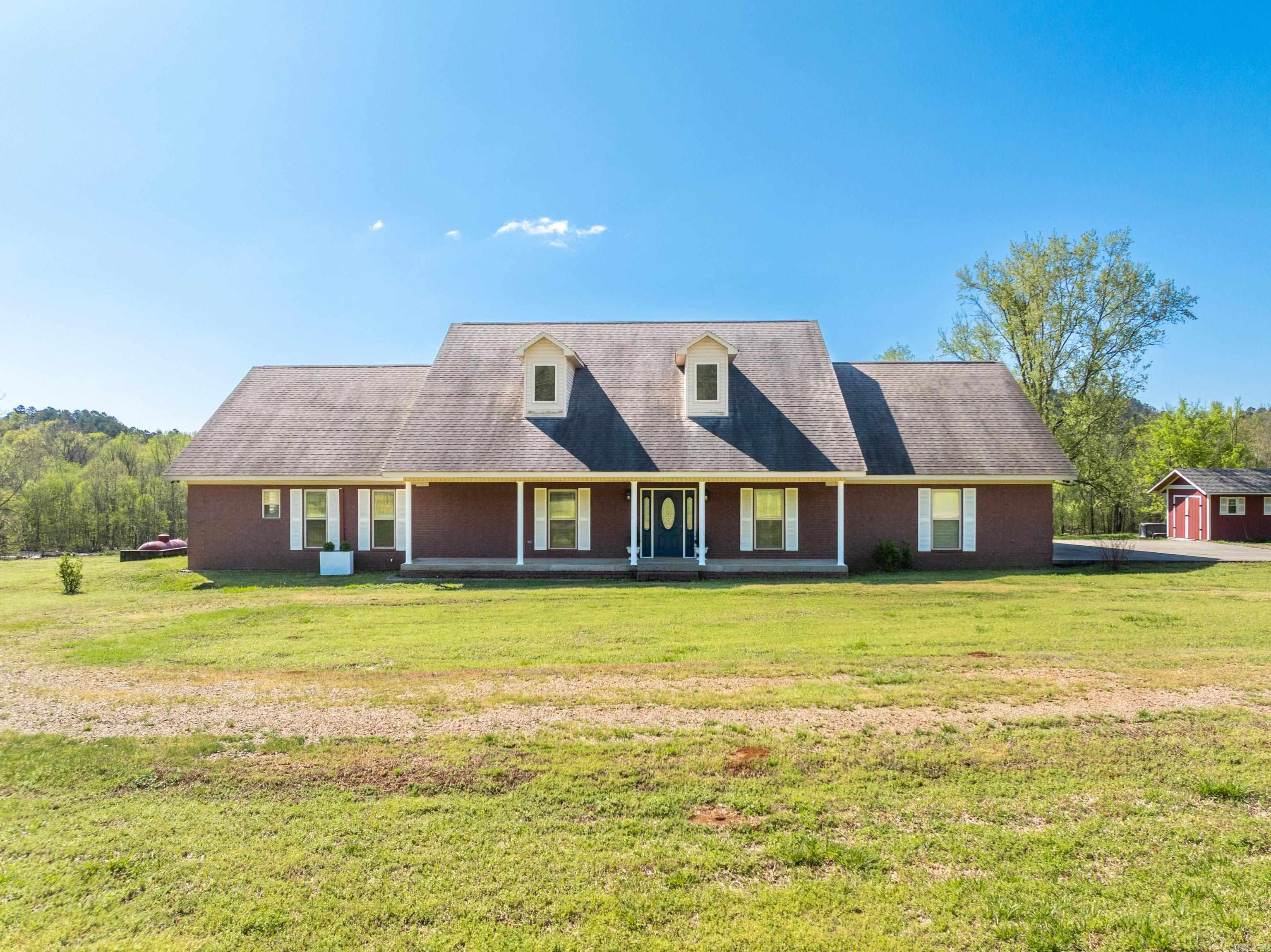 WELCOME TO YOUR DREAM RETREAT in beautiful Norman, Arkansas! This spacious 3 bedroom, 2 bath, all-brick home boasts an expansive 2,478 sq. ft. of open living space, nestled on a sprawling 20-acres with breathtaking vista views overlooking 500 feet of picturesque Caddo River frontage! This property includes a charming 1,000 sq. ft. separate home currently operating as an Airbnb. This cozy space features 1 bedroom, 1 bath and comes fully furnished, complete with appliances and central heat and air, making it turn key! Step inside the main house to discover a thoughtfully designed interior featuring 9-foot ceilings and tons of storage throughout. The kitchen features gorgeous solid surface countertops, gas stove, microwave, dishwasher and refrigerator. The spacious living room has vaulted ceilings and cozy gas fireplace. Home is equipped with a 20,000 kW standby generator, two-car oversized garage, central vacuum, and 2x6 exterior walls, ensuring comfort and efficiency year-round.This property also has an electric gated entrance and a 30' x 40' storage quantum hut equipped with electric and plumbing.