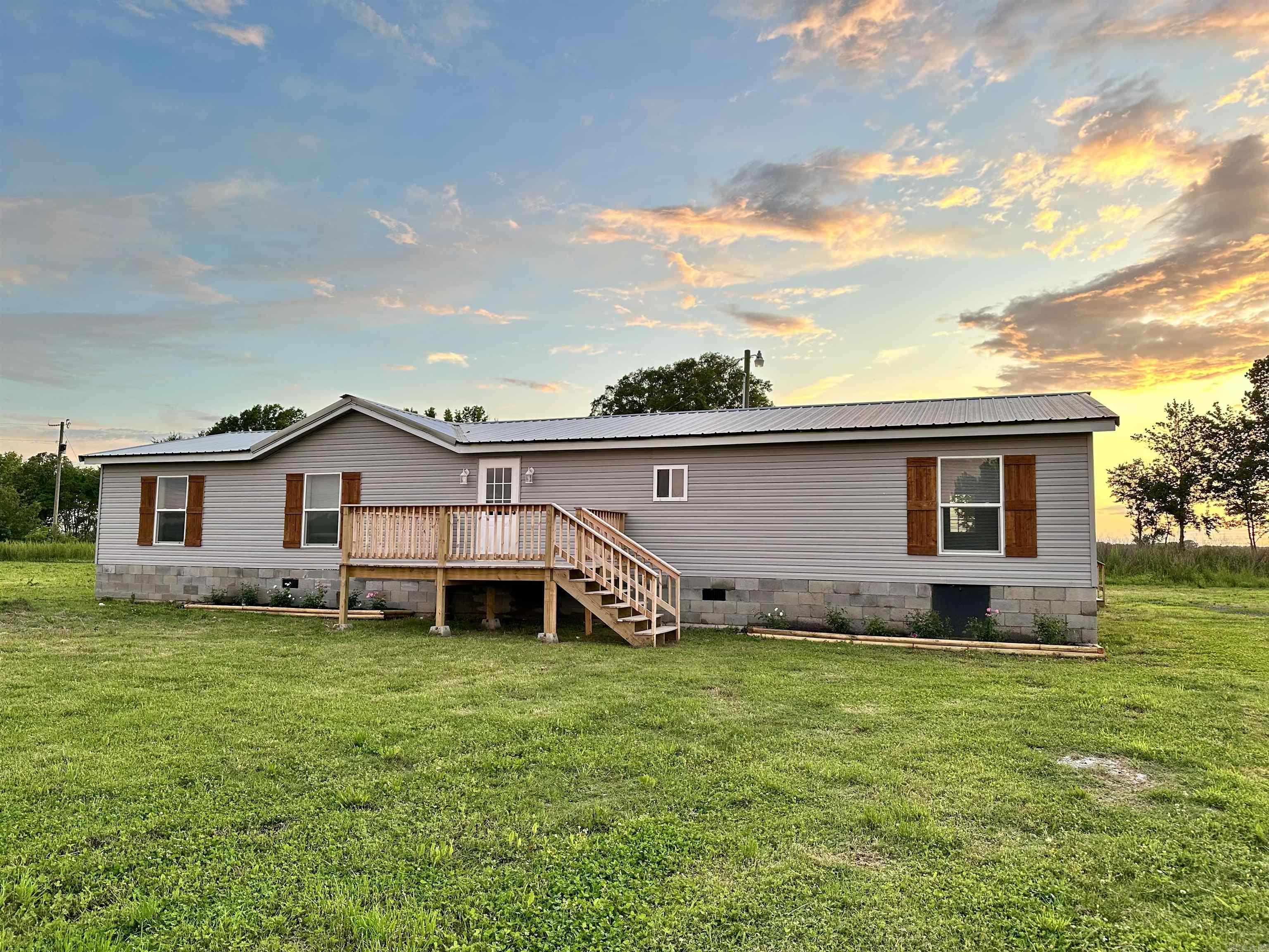 Enjoy living out in the country? Well check out this renovated manufactured home on 3 acres of FLAT LAND, plenty of space for your horses and cows to roam! This move-in ready home has 4 bedrooms, 2 baths, and one half bath. The kitchen has a nice butcher block island that gives the home a farmhouse style with BRAND NEW APPLIANCES. Fresh paint and new vinyl flooring throughout the house. Updated bathrooms with beautiful tiles! New large deck to relax and enjoy your yard with a beautiful sunset view! Please schedule your showing now! Back on the market at no fault of the seller.