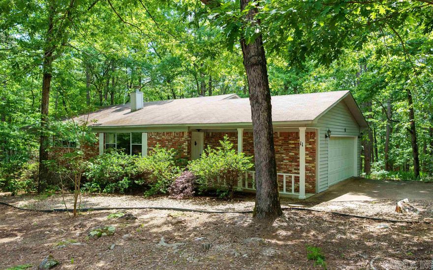 Lovely home on a corner lot with a wooded view. Conveniently located close to many Hot Springs Village area amenities including the Fitness Center, library, tennis courts, lake and trails. This would be a wonderful vacation home or forever home.  The interior features an open floor plan with 3 nice sized bedrooms and 2 full baths. The kitchen has a breakfast bar and plenty of storage. The peaceful back deck has an uninterrupted view of the woods so you can enjoy nature with no houses next door or behind the home. Don't miss out on this lovely home.