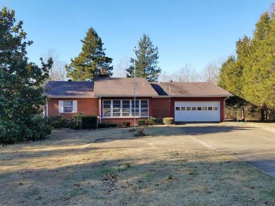 4 Menominee in Cherokee Village, Arkansas offers a wonderful location with a spacious, level yard stretching side to side. This inviting home features two comfortable bedrooms and one and three-quarter baths, designed for ease of living. The living room is highlighted by a cozy gas log fireplace, while the kitchen provides abundant oak cabinetry and a side-by-side refrigerator. A dining area opens through patio doors into an enclosed sunroom, creating a seamless blend of indoor and outdoor enjoyment. The interior is finished with drywall, and the exterior combines brick and metal siding for durability. The heat pump, though older, has been serviced regularly twice a year, ensuring reliable performance. Double-pane windows enhance energy efficiency, and the property includes an attached two-car garage as well as a detached two-car garage with an additional carport, offering ample parking and versatile shop space. This home combines comfort, practicality, and charm in a desirable setting.