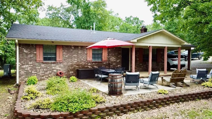Tucked away on 16 wooded acres, this charming residence offers the perfect blend of privacy and seclusion. A beautifully landscaped front patio and covered porch welcome you, surrounded by mature shade trees and a peaceful fishing pond—creating a tranquil, year-round retreat. Inside, a cozy living area features a striking wood-burning fireplace framed by warm shiplap walls. The eat-in kitchen boasts solid surface granite countertops, built-in stainless steel appliances, a breakfast bar, and a pantry for added convenience. A versatile bonus room offers ideal flex space for a home office, craft room, or workshop. Recent updates ensure peace of mind, including a new roof (2020), HVAC system (2022), and hot water heater (2024).
