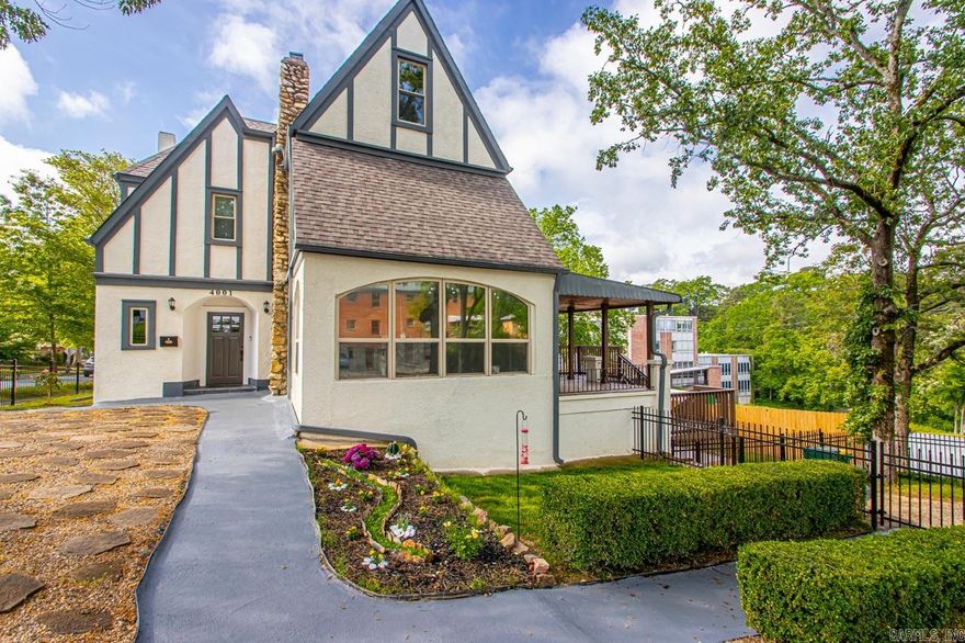 Step into 1927 charm, lovingly restored. This English Revival Tudor in the heart of Hillcrest blends timeless architecture, including peaked gables, wood beams, and hand-laid stonework, with a full designer remodel. A storybook yard welcomes you with iron fencing, artistic landscaping, and curated garden beds. Inside, restored wood paneling, warm floors, and a stunning stone fireplace create a cozy yet refined feel. The Arkansas Room and covered porch offer peaceful spaces to unwind. The kitchen stuns with top-tier appliances and an open prep and dining area perfect for hosting. Upstairs, the primary suite is a true retreat with dual closets, a spa-like bath, and a custom wall mural. Two sun-filled bedrooms and a top-floor studio, original to the home’s design, round out the charm. The finished basement adds even more living space, a second laundry, and access to the new deck. Just steps from Kavanaugh, Hill Station, Mylo, and Alsop Park, this is a rare gem in one of Little Rock’s most beloved neighborhoods.