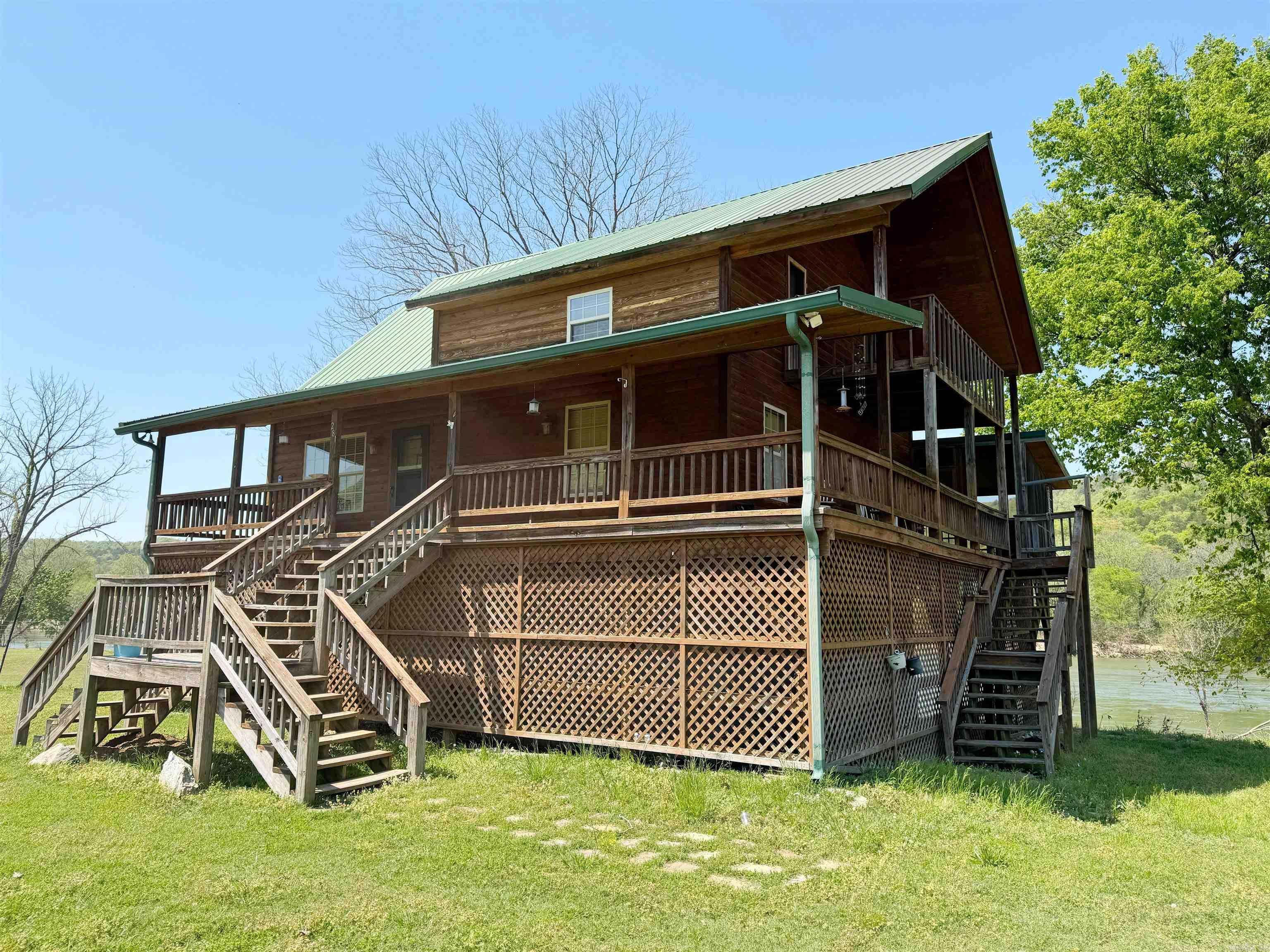 This beautiful 3-bedroom, 2-bath cabin sits on 1.95 scenic acres along the White River with views on all sides and offers 1,650 sq ft of comfortable living space. Inside, you'll find a spacious living area with a floor-to-ceiling stone fireplace and vaulted ceilings. The screened-in porch overlooks the river, perfect for relaxing or entertaining, and there’s a fire pit just steps away for enjoying evenings outdoors. The home is being sold fully furnished, including high-quality, custom-made furniture that fits the rustic cabin style. A public boat ramp is located at the beginning of the street, making river access quick and easy. Whether you're looking for a weekend getaway or a full-time home, this property offers peace, privacy, and a great location. Riverfront cabins like this don’t come along often—at this price, it won’t last long.