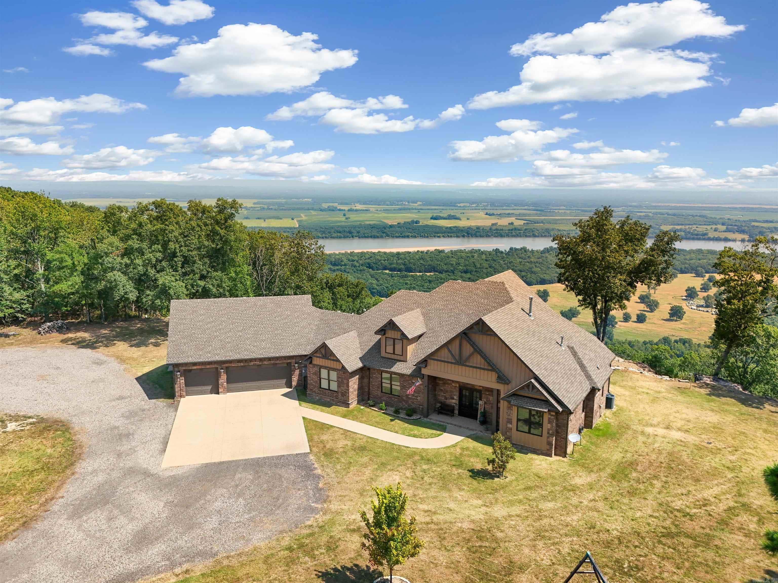 Gorgeous Home with Unmatched Views on the brow of Petit Jean Mountain! Step into luxury & comfort with this stunning custom-built home; offering breathtaking panoramic views of the AR. River & surrounding mountain ranges. This one-of-a-kind property features 3 Bed., 2.5 baths, office & bonus room. Tile floors throughout, with 12 'ceilings in kitchen & primary suite & a soaring 14-foot ceiling in the living area adorned with beautiful wood beams & custom built in wood shelving. Kitchen is a chef's dream with granite countertops, commercial size refrig. Enjoy natural light & sweeping views through a wall of windows across the back of home. Primary suite features a spa-like bath retreat & an oversized Walk-in closet. Wait- yes for your tools, toys or workshop dreams - 72'X40' Garage/shop - 16 ft. walls.