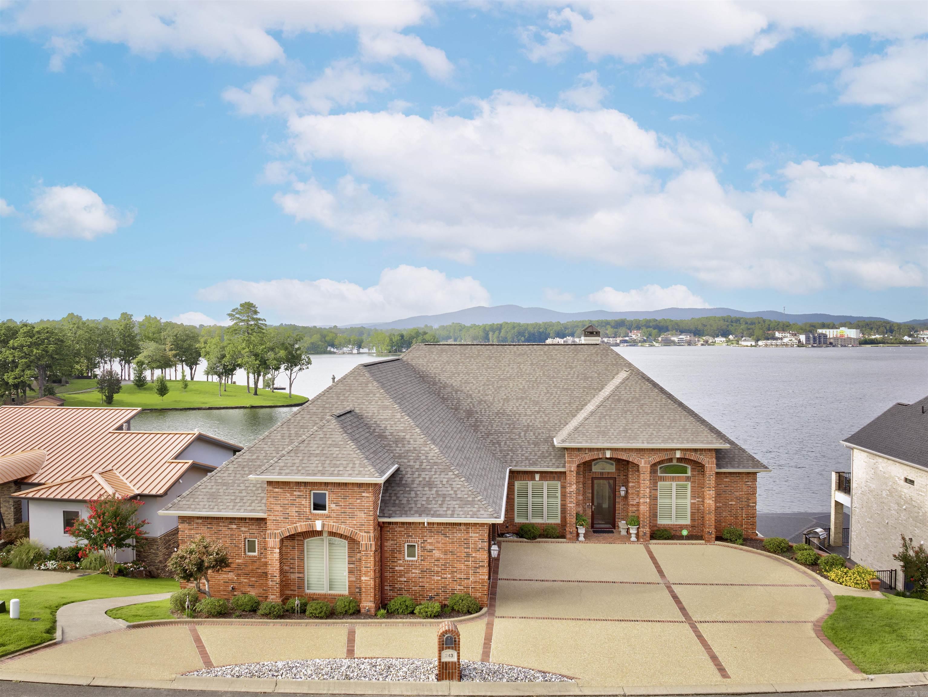 A rare offering on Lake Hamilton, this exceptional custom-built waterfront estate blends architectural refinement with understated luxury. Designed for elegant living and effortless entertaining, the home features 5 bedrooms, 5.5 baths, a gourmet kitchen with granite countertops professional grade appliances, and a separate lower-level suite with full kitchen ā ideal for guests or multi-generational living. The gracious primary suite offers a spa-like retreat with an expansive walk-in closet, while a dedicated office adds practicality to the timeless design. Outdoors, enjoy a thoughtfully created cart path to the water, refinished dock and boat lift, and inviting entertaining spaces overlooking the water. A true expression of Southern elegance, every detail adds a touch of Lagniappe on the lakeā that ālittle bit extraā that sets this property apart. (Full house generator is present and a full list of updates and improvements available upon request.)