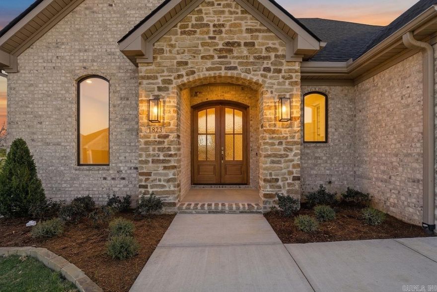 Welcome to Mountain Brook, West Little Rock’s most anticipated new community, ideally located just off Hwy 10. This thoughtfully designed single-level new construction home offers 3 bedrooms, 2 full baths, 1 half, & a versatile bonus space ideal for a private study, lounge, or wellness retreat. The expansive open-concept kitchen, dining, & living area feels refined yet inviting, with oversized windows that flood the home with natural light and create seamless sightlines to the covered outdoor living space, complete with fireplace for elevated year-round entertaining. The primary suite serves as a serene retreat featuring a spa-inspired bath with soaking tub, separate tiled shower, dual vanities, & a spacious walk-in closet designed for effortless organization. Two additional bedrooms are privately positioned & beautifully appointed, while the well-placed half bath adds convenience for guests.