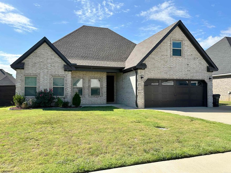 This elegant brick home, constructed in 2022, is situated within the Eden Hills Subdivision of the Brookland School district and falls within the city limits of Jonesboro, benefiting from CWL services.  Home has 5 bedrooms & 3 full baths, with 12-foot raised ceilings spanning the great room, kitchen & dining area. Multiple windows surround the dining area, providing abundant natural light.  The master suite offers tray ceilings, an en-suite bathroom with double sinks, a soaker tub featuring tile surround, a custom-tiled shower with a glass door & an oversized walk-in closet. Luxury vinyl flooring extends throughout the great room, bedrooms & hallways, while the laundry room, kitchen &  bathrooms feature tile flooring, and carpeting is limited to the stairs. Amenities include crown molding, ceiling fans, wood shelving units in all closets, granite countertops in both the kitchen and bathrooms, a tiled backsplash, a tankless water heater, gas log fireplace, screened porch, patio &  foam insulation + upgrades: front porch, gas stove/griddle/double oven, pot filler, 3rd bath, 3rd parking, garage & front door, microwave drawer, vent hood, smart mirrors.  Horizontal slat fence added 2023