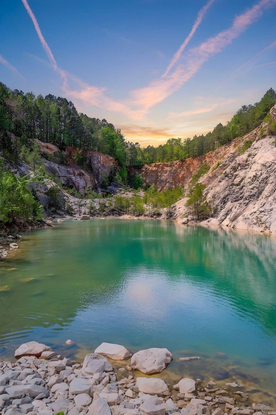 180.91± acres located just off Highway 270 in Malvern, AR, offering a truly one-of-a-kind land opportunity in Hot Spring County. Formerly a rock quarry, this property features dramatic cliffs, striking rock formations, and turquoise-colored water features that create an unforgettable landscape.  The terrain offers a mix of elevated overlooks and secluded valley areas, providing both privacy and breathtaking views throughout the property. With its natural beauty and unique topography, the current owner had envisioned development as an outdoor hot spring resort and wedding/event venue, showcasing the property's destination potential.  Conveniently located a short drive from Hot Springs National Park, this tract combines accessibility with a secluded, scenic setting. Whether for recreation, investment, or a visionary development project (subject to buyer verification), this property—often referred to as “Nature’s Paradise”—is a rare find with exceptional character. Agents see remarks