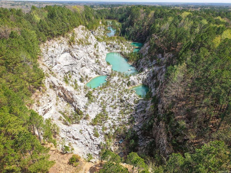 180.91± acres located just off Highway 270 in Malvern, AR, offering a truly one-of-a-kind land opportunity in Hot Spring County. Formerly a rock quarry, this property features dramatic cliffs, striking rock formations, and turquoise-colored water features that create an unforgettable landscape.  The terrain offers a mix of elevated overlooks and secluded valley areas, providing both privacy and breathtaking views throughout the property. With its natural beauty and unique topography, the current owner had envisioned development as an outdoor hot spring resort and wedding/event venue, showcasing the property's destination potential.  Conveniently located a short drive from Hot Springs National Park, this tract combines accessibility with a secluded, scenic setting. Whether for recreation, investment, or a visionary development project (subject to buyer verification), this property—often referred to as “Nature’s Paradise”—is a rare find with exceptional character. Agents see remarks