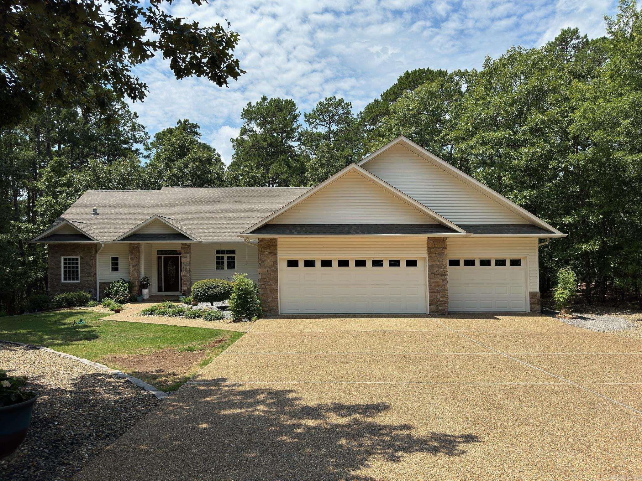 Nestled in wooded serene surroundings this beautiful home is in a gated community. 3 bedrooms, 2 baths, and a three-car garage. Spectacular foyer with a 11-foot ceiling. Crown molding throughout the main living areas and primary bedroom suite. Wood burning fireplace, kitchen and dining room combo. Inviting kitchen has two sinks and gorgeous quartz countertops. All stainless-steel appliances, breakfast bar, plenty of cabinets, built-in China cabinet in dining room, a second pantry, laundry room, W/D convey. Enjoy the separate primary bedroom suite with his and hers walk-in closets. Both primary and guest bathroom has double sinks, and a toto bidet toilet with settings for heated seat and water. Second bedroom is quaint and has a glass door leading out to the deck. Relax in the screened sunroom. It gives you that outdoors feeling but with the indoor comfort. Rebuilt deck is a nice outside retreat for entertaining and cookouts. This home is being sold by the original owner and has been well maintained. New roof in 2023, new sprinkler system and hot water heater in 2024 and there is additional storage under the house. Do not miss out on this captivating home. Schedule a showing today!